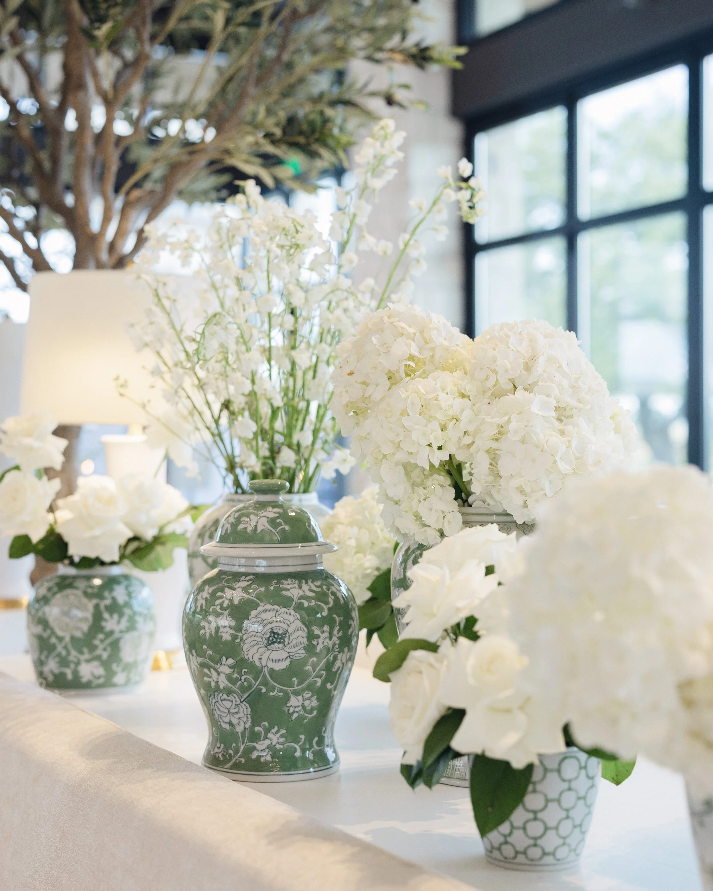  Green and white chinoiserie ginger jar filled with white hydrangea on a windowsill ledge 