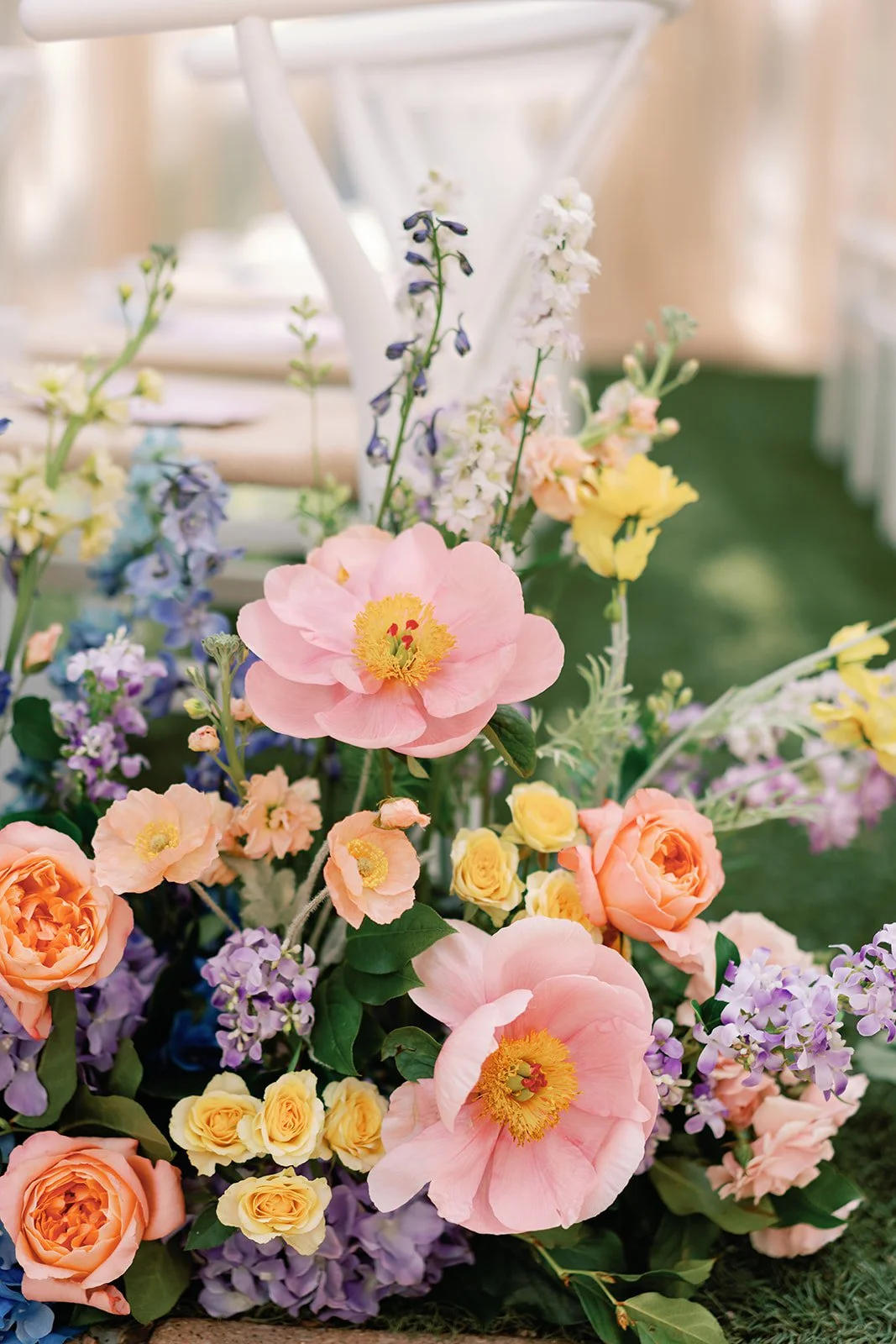  Close up floral arrangement with pink poppies, peach garden roses, and lavender delphinium at Four Seasons Austin wedding ceremony 