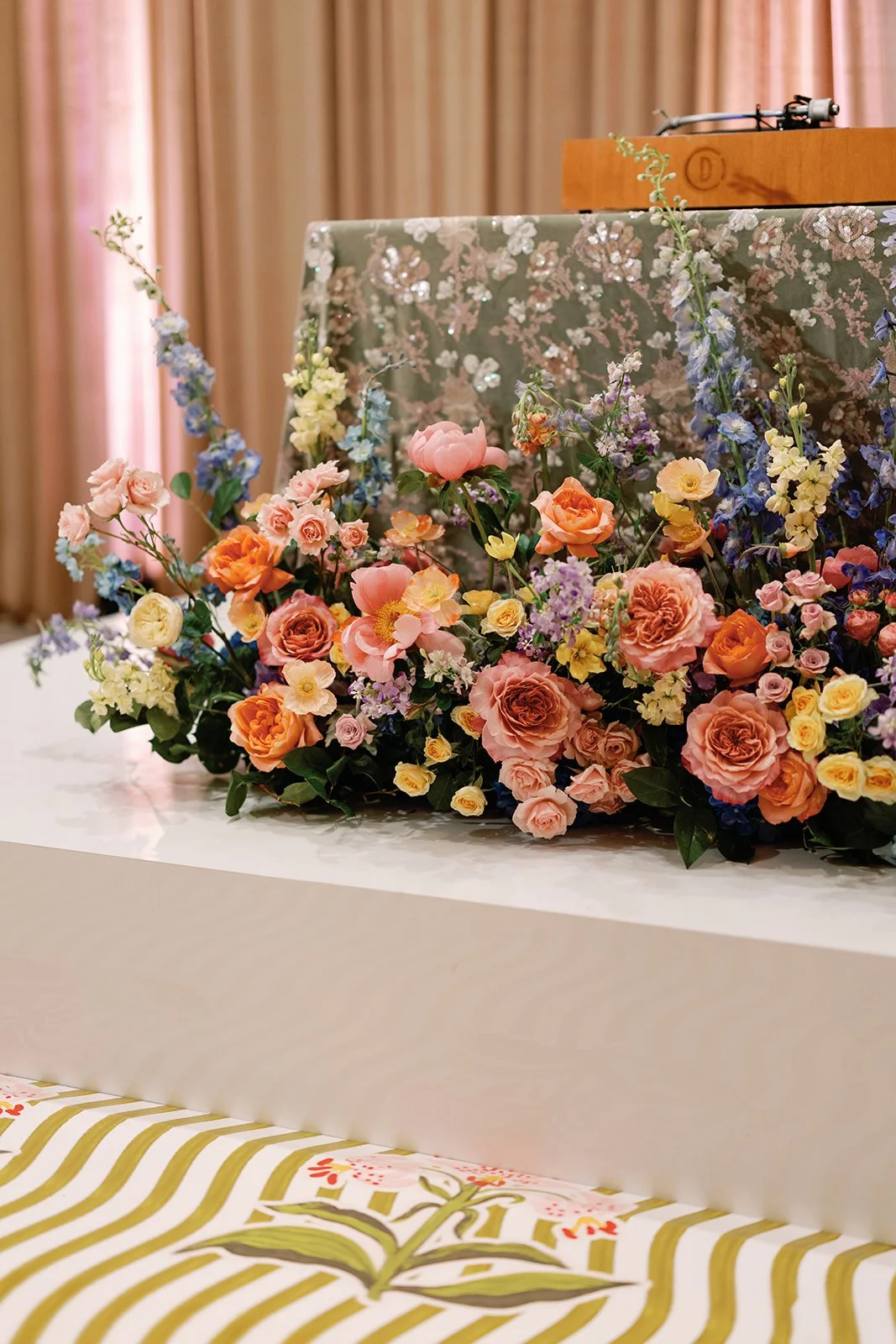  Cascading floral arrangement on a white platform above a hand painted striped dance floor 