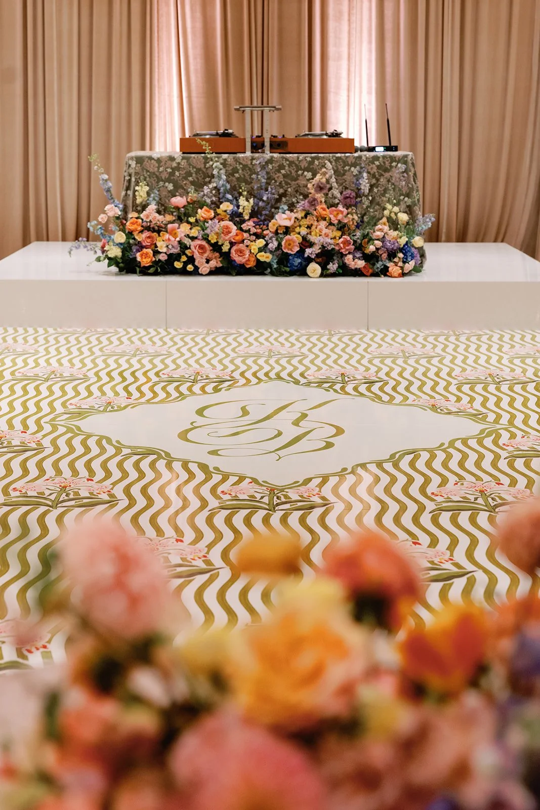  Floral arch and table backdrop with hand painted monogrammed dance floor in the foreground 