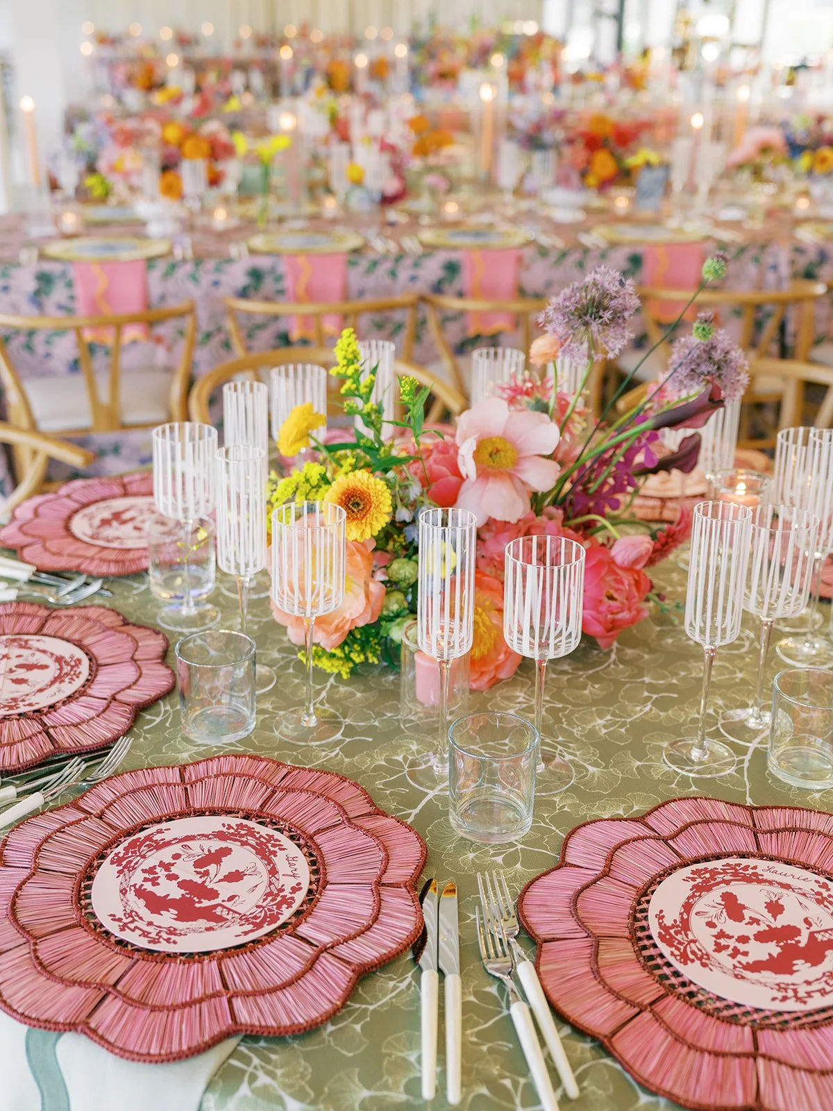  Reception table detail with pink flower shaped chargers and a colorful centerpiece 