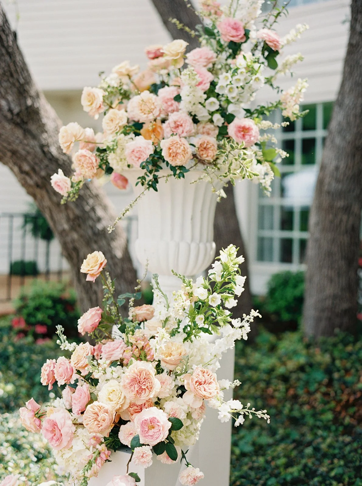  Blush and peach ceremony florals by Remi + Gold under the live oak at Commodore Perry Estate in Austin 