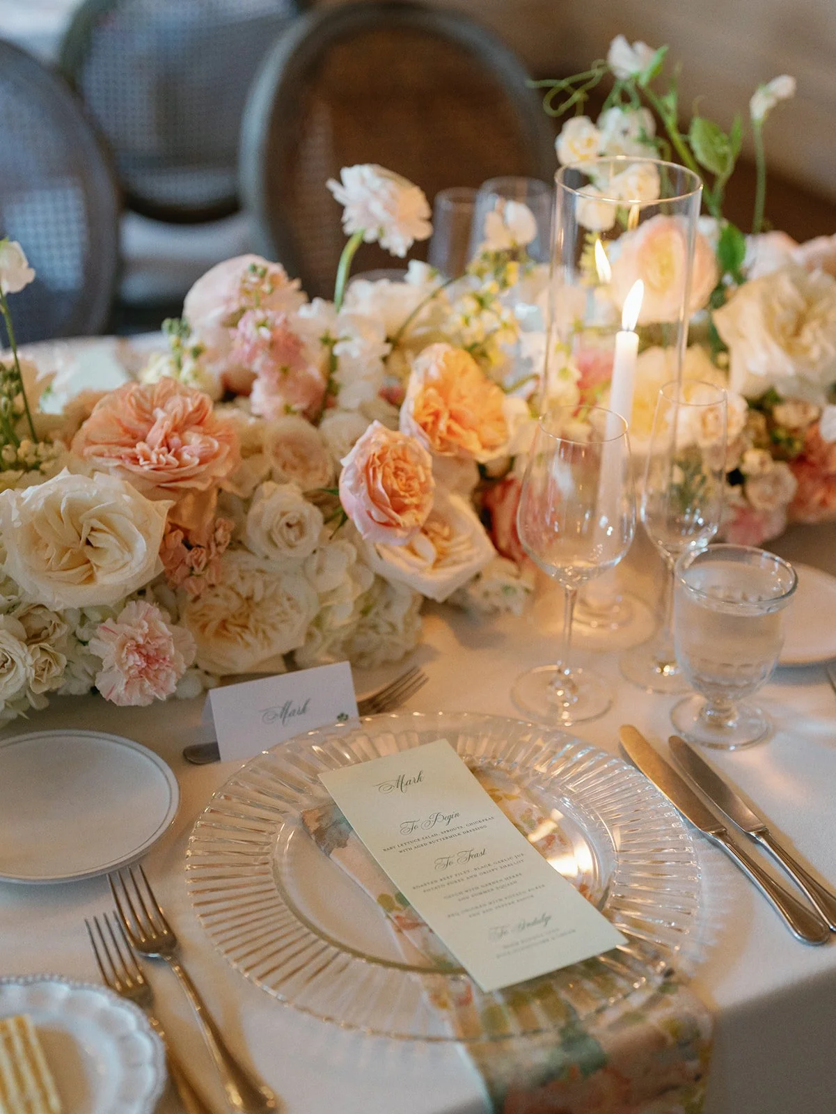  Reception tables with cane-back chairs and garden rose centerpieces beneath arched windows at Commodore Perry Estate 