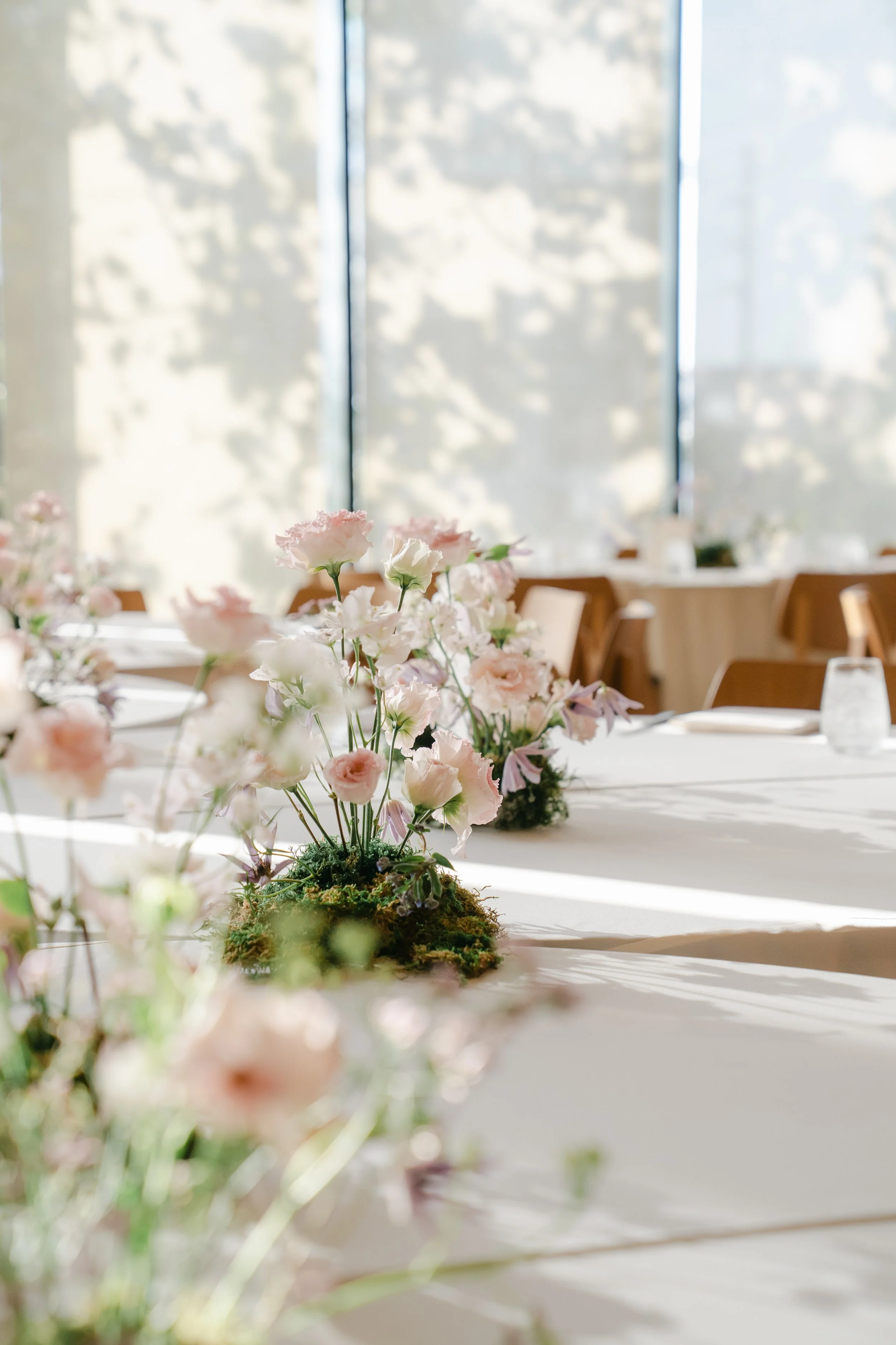  Delicate pink and lavender centerpieces catching afternoon light in the ballroom at Austin Proper Hotel in downtown Austin 