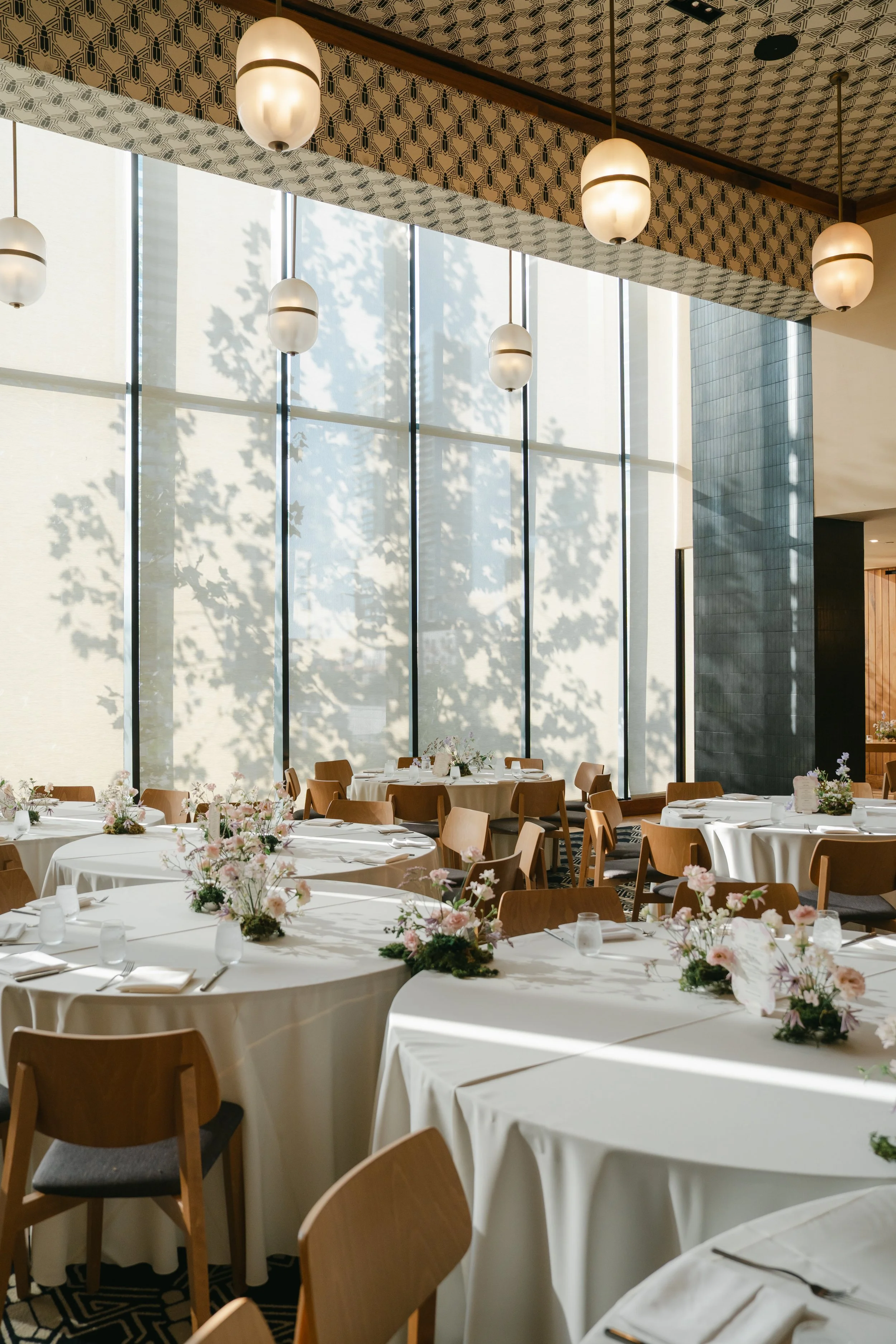  Sangeet reception tables with moss-based floral arrangements beneath globe pendant lights at Austin Proper Hotel 