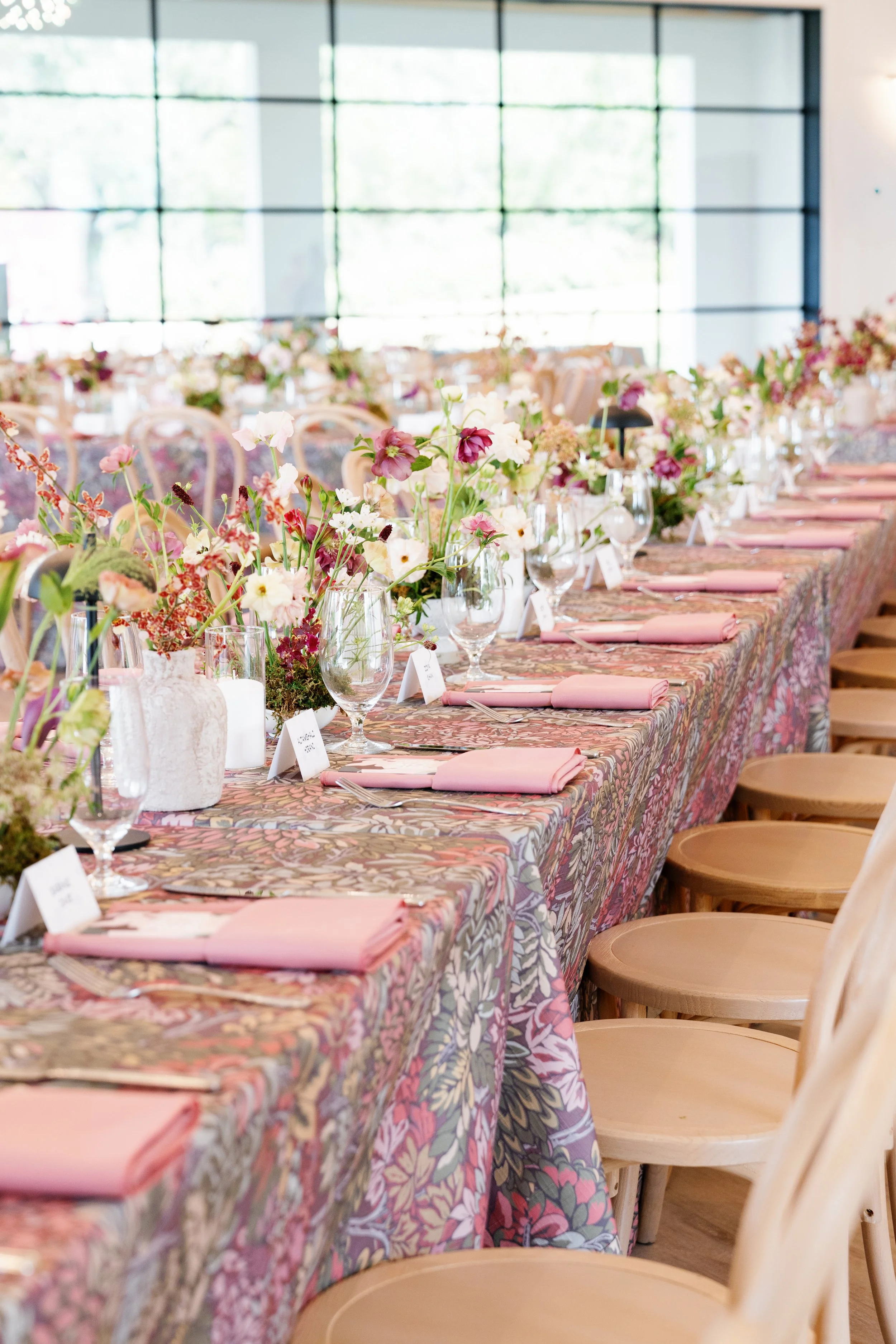  Close-up of burgundy branches and blush blooms in a ceramic vessel at a wedding reception at The Arlo 
