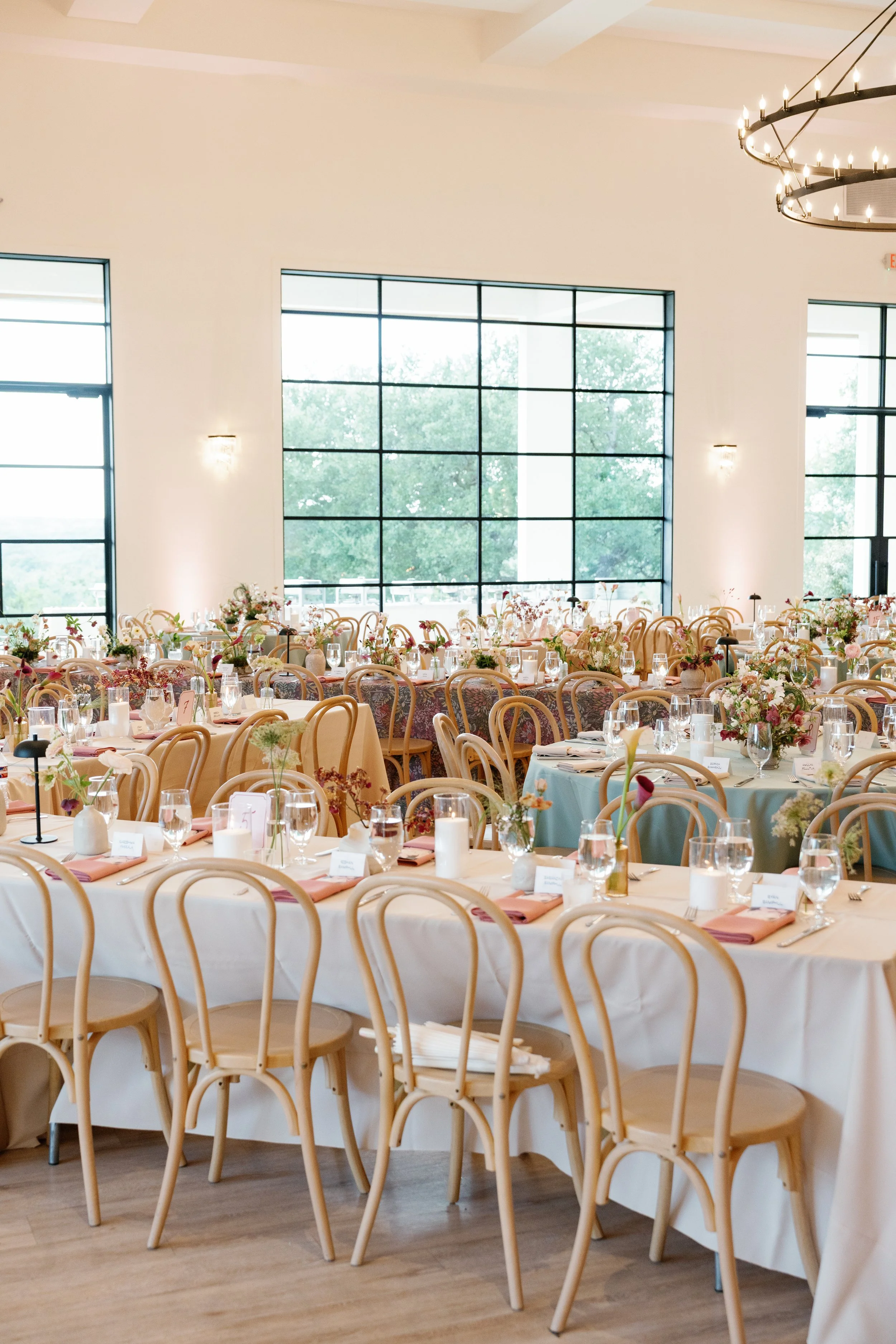  Mix of long and round reception tables with patterned linens and colorful florals in the ballroom at The Arlo 