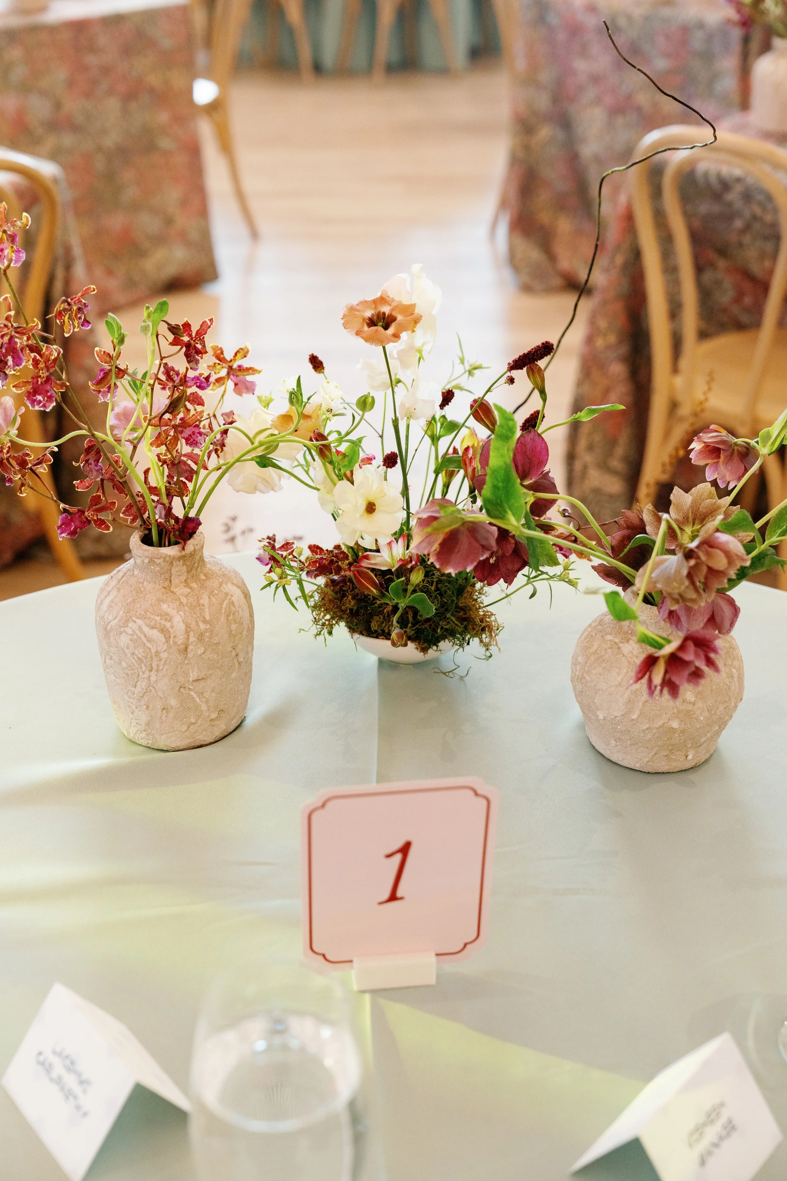  Loose centerpieces of garden roses and calla lilies on a sage linen table at The Arlo 