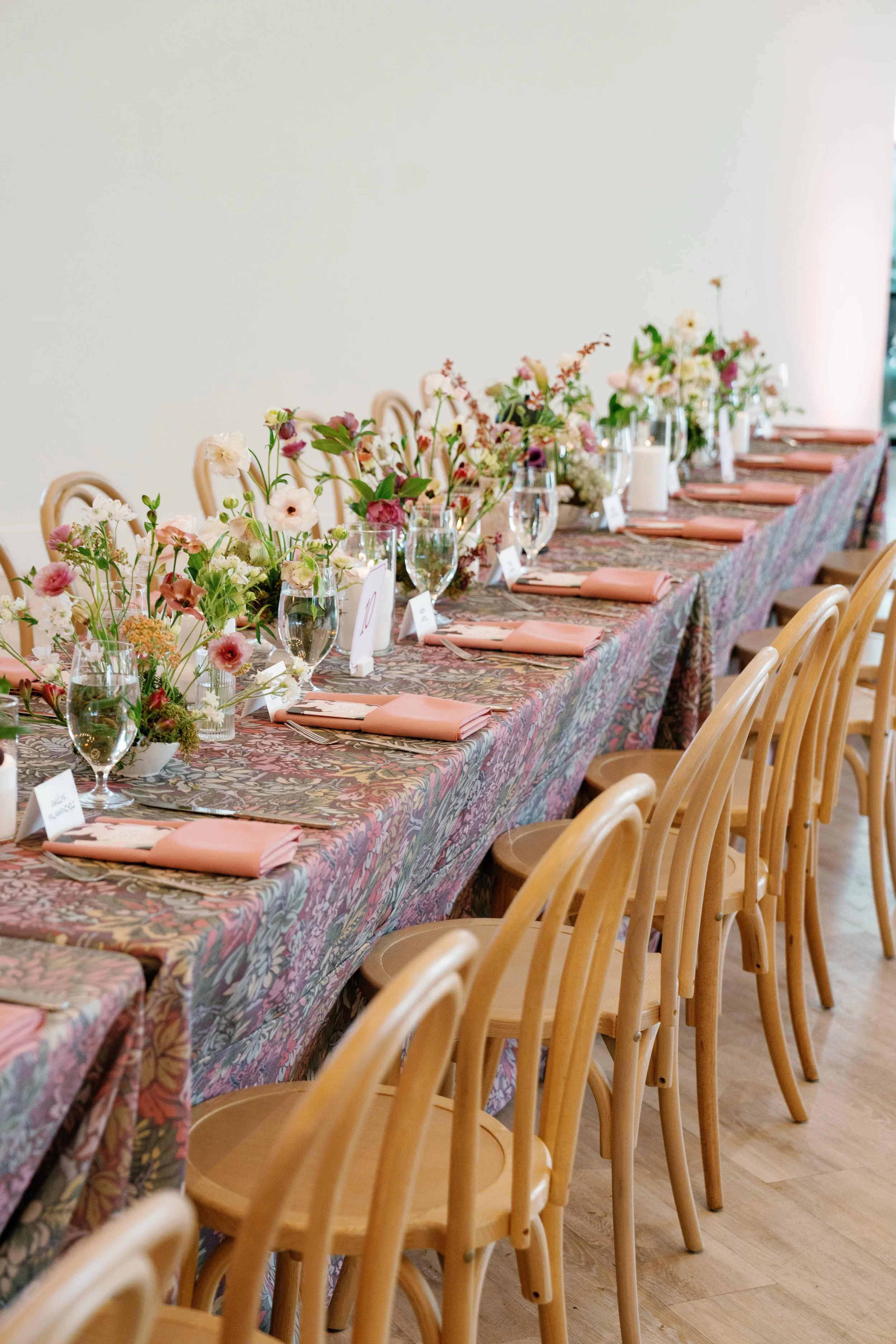  Burgundy, mauve and blush wedding reception florals beside the paned windows of the ballroom at The Arlo 