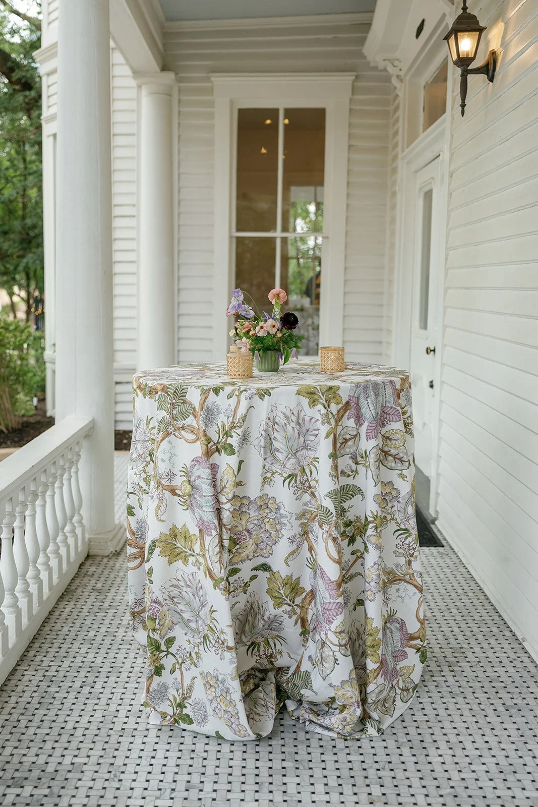  Small arrangement of peach and lavender blooms with a gold votive on a sage linen table at The Allan House 