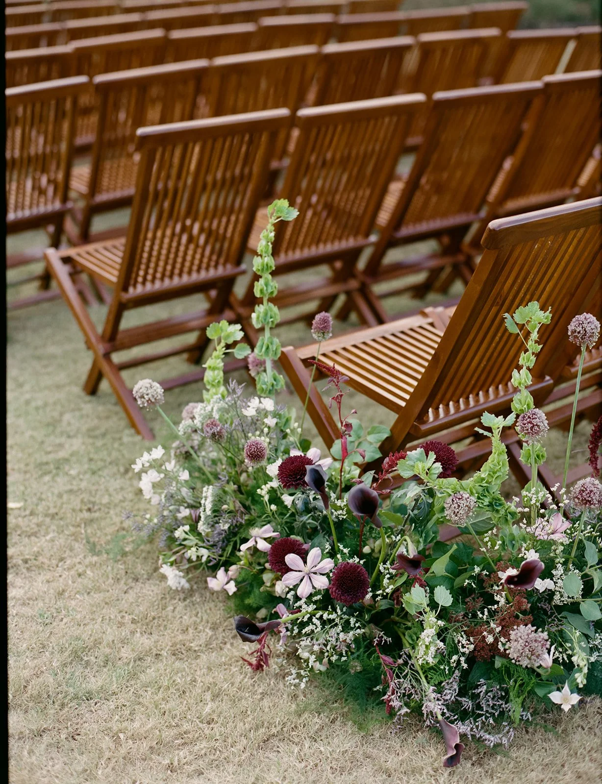  Wedding ceremony on the lawn in front of Ian’s Chapel at Camp Lucy with low aisle florals by Remi + Gold 