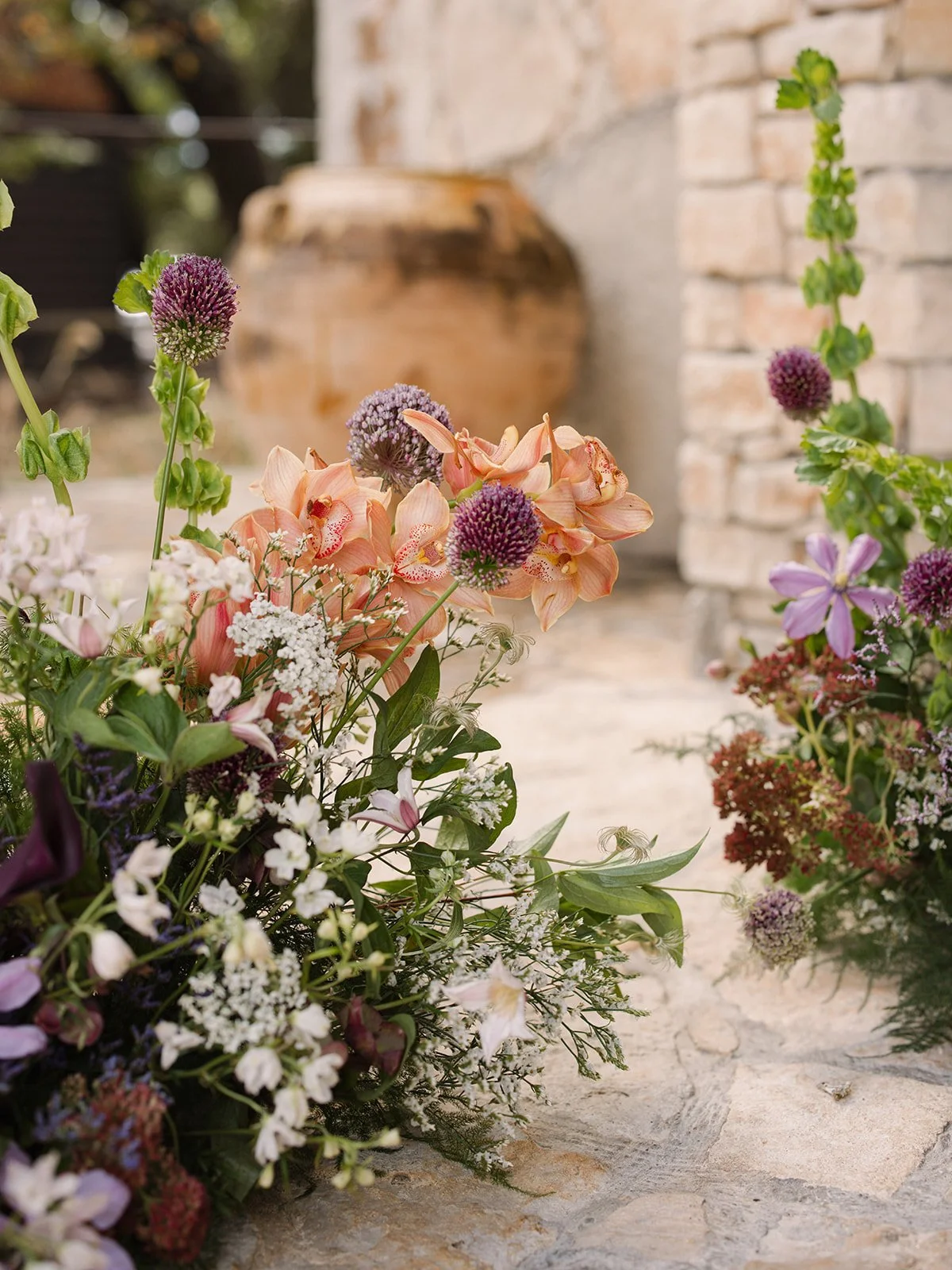  Apricot blooms, allium and greenery in a low aisle arrangement at Ian’s Chapel in Dripping Springs 