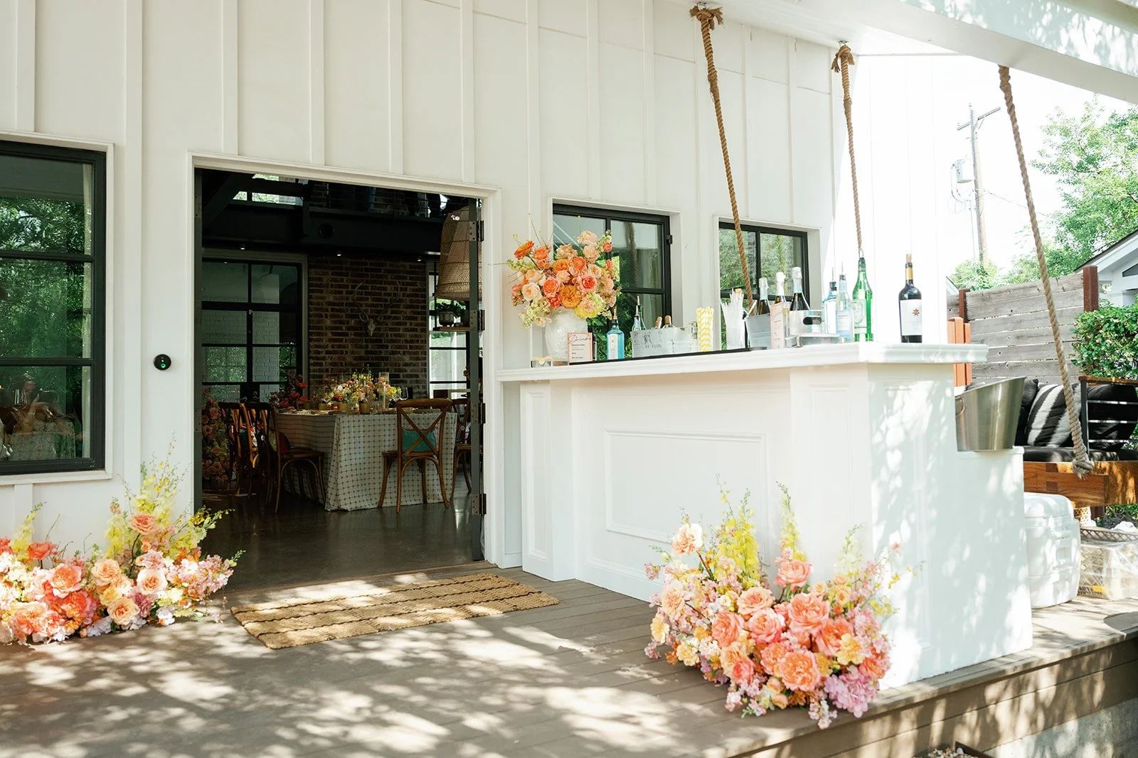 Entrance into an Austin summer corporate event with florals at the bar.
