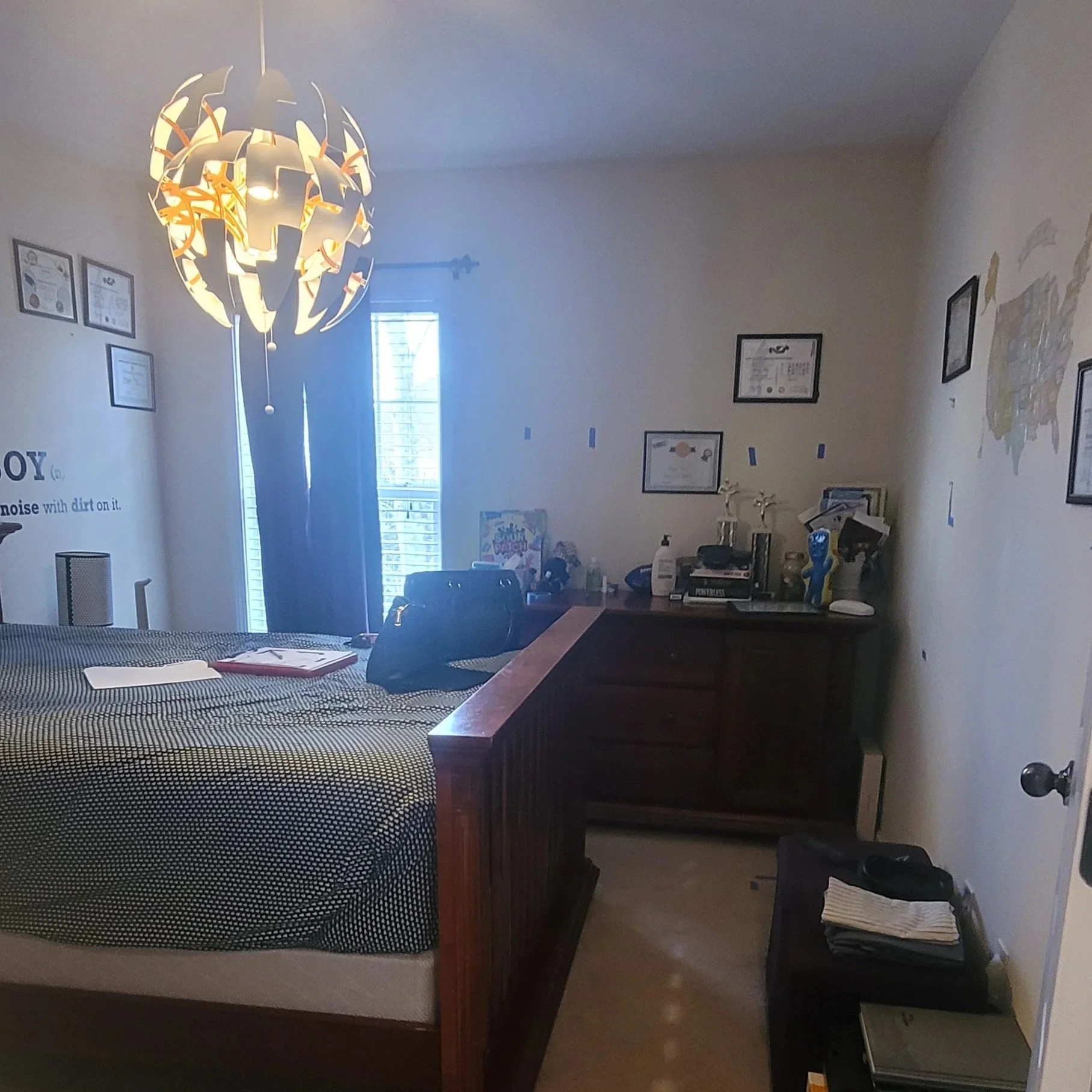 Interior design mood board with a neutral color palette including beige, black, and light gray for a living room featuring a beige sofa, beige armchairs, black and white accessories, a modern black ceiling fan, a tall floor lamp, a small round black and beige side table, a potted plant, and an unfinished room sketch with stairs in the background.