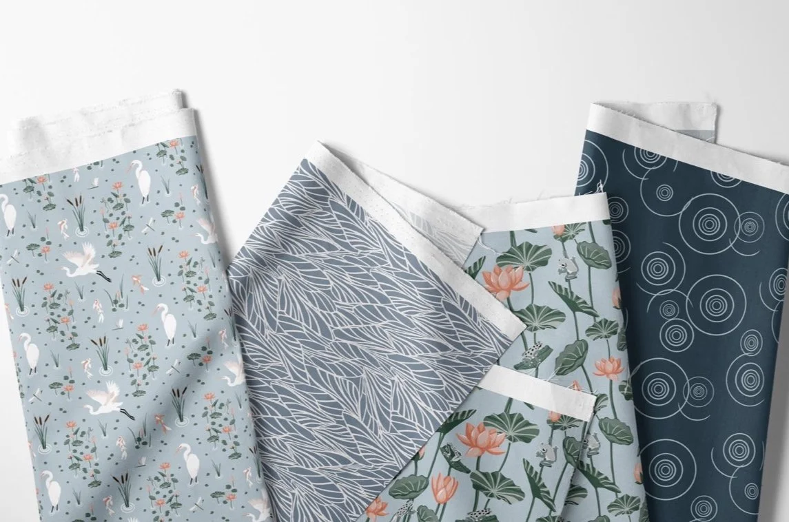 nature inspired tranquil fabric collection with dragonfly wings, white herons, water lilies, koi fish, and cattail plants, in soothing shades of blues and sage greens.