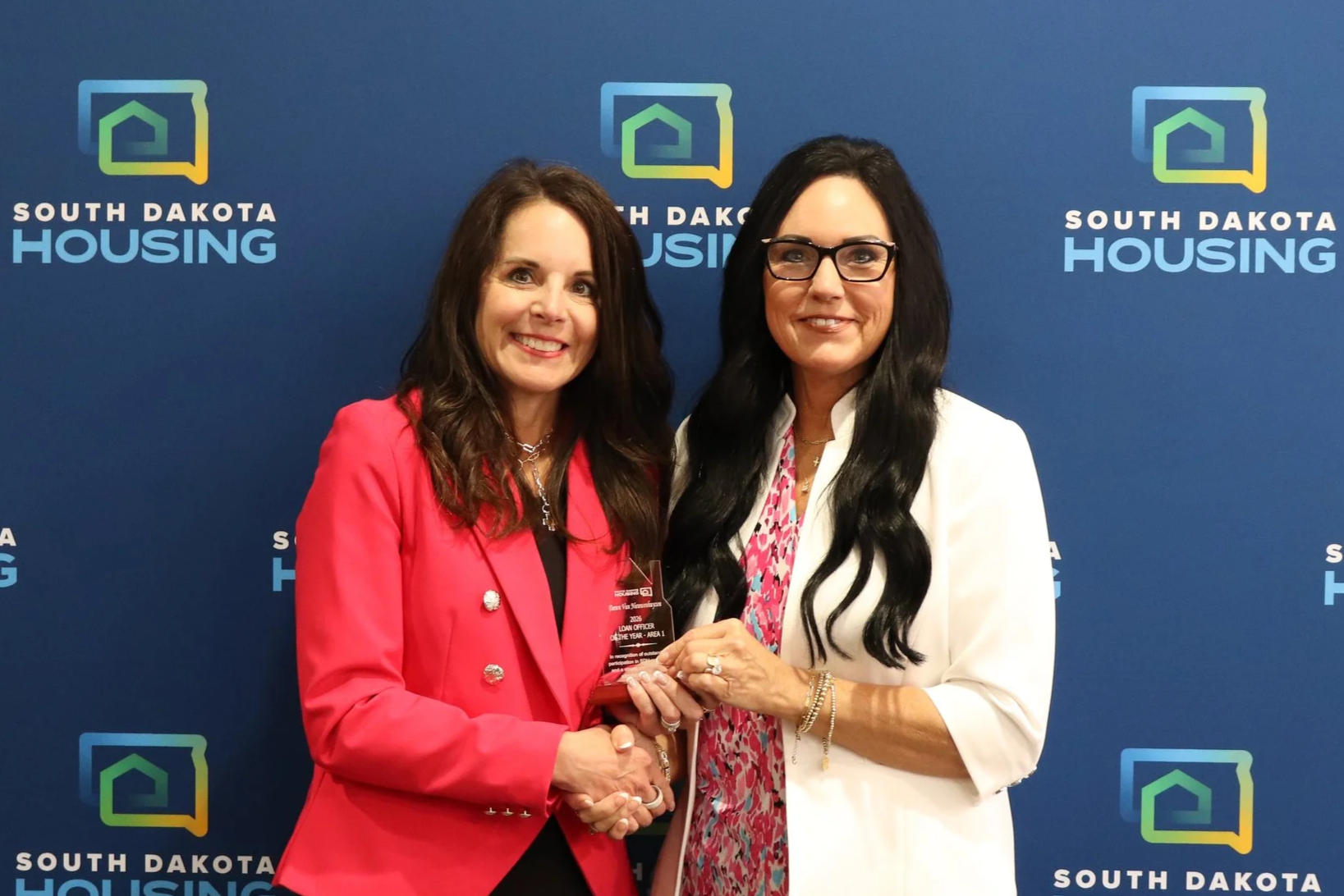 Dawn Van Nieuwenhuyzen with Plains Commerce Bank receiving her award from Homeownership Director Tammy Jund