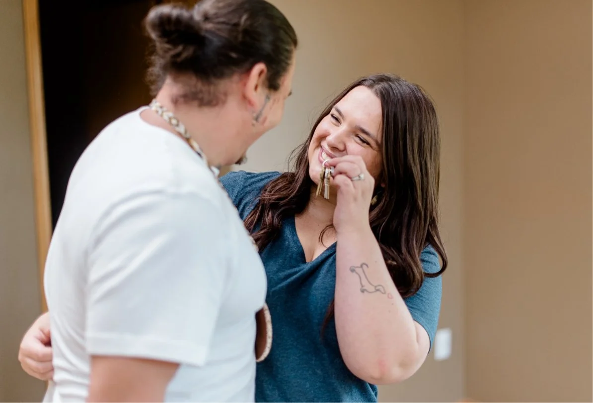 Couple smiling at each other while holding new house keys.