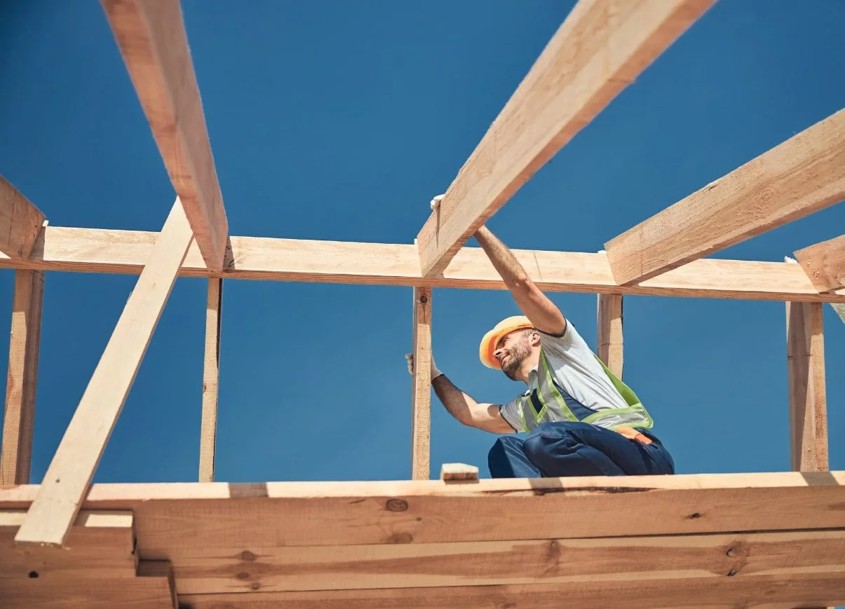 Construction worker setting rafters of a structure.