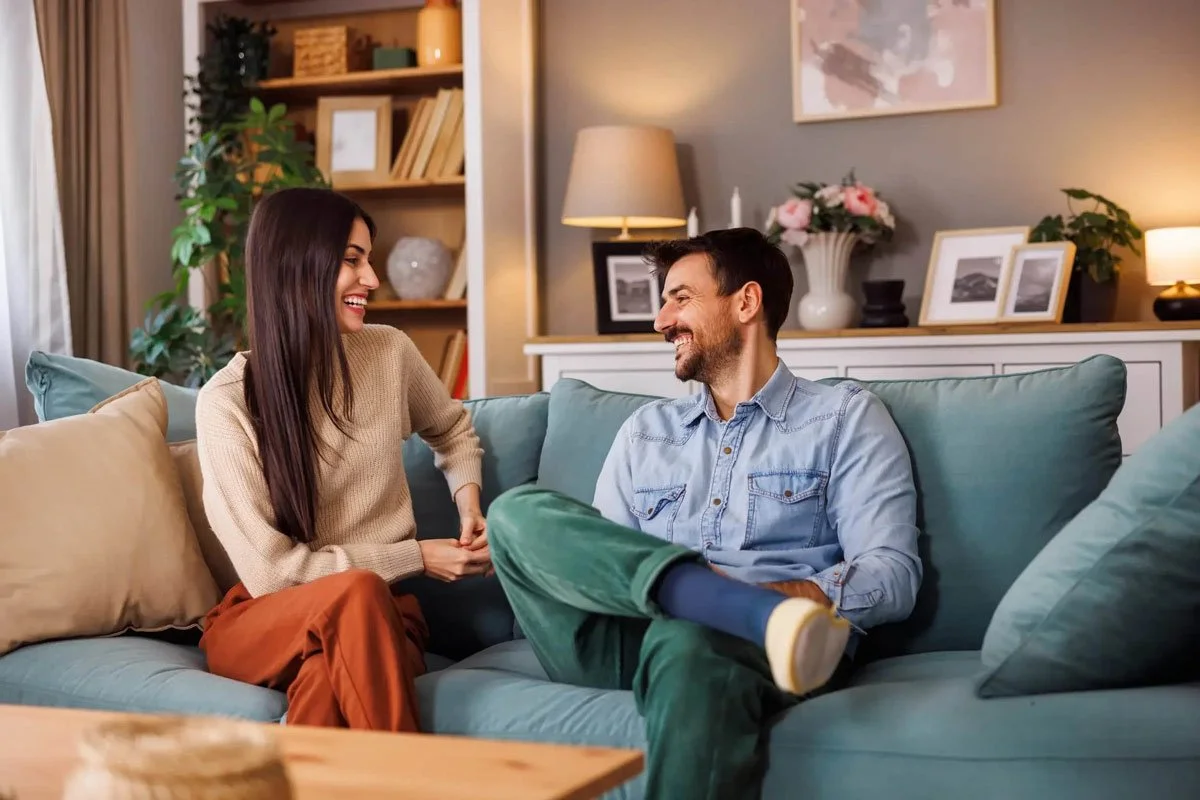 Couple laughing at home on couch
