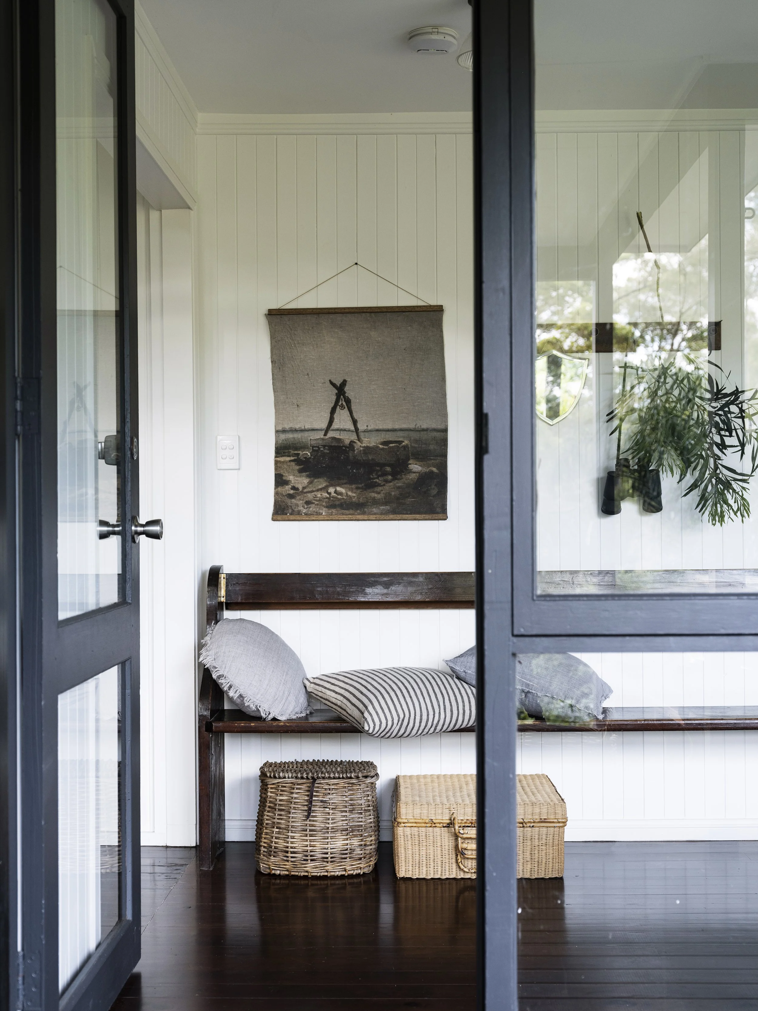 Entryway at Seals Way A-frame cabin with natural textures and vintage wall art