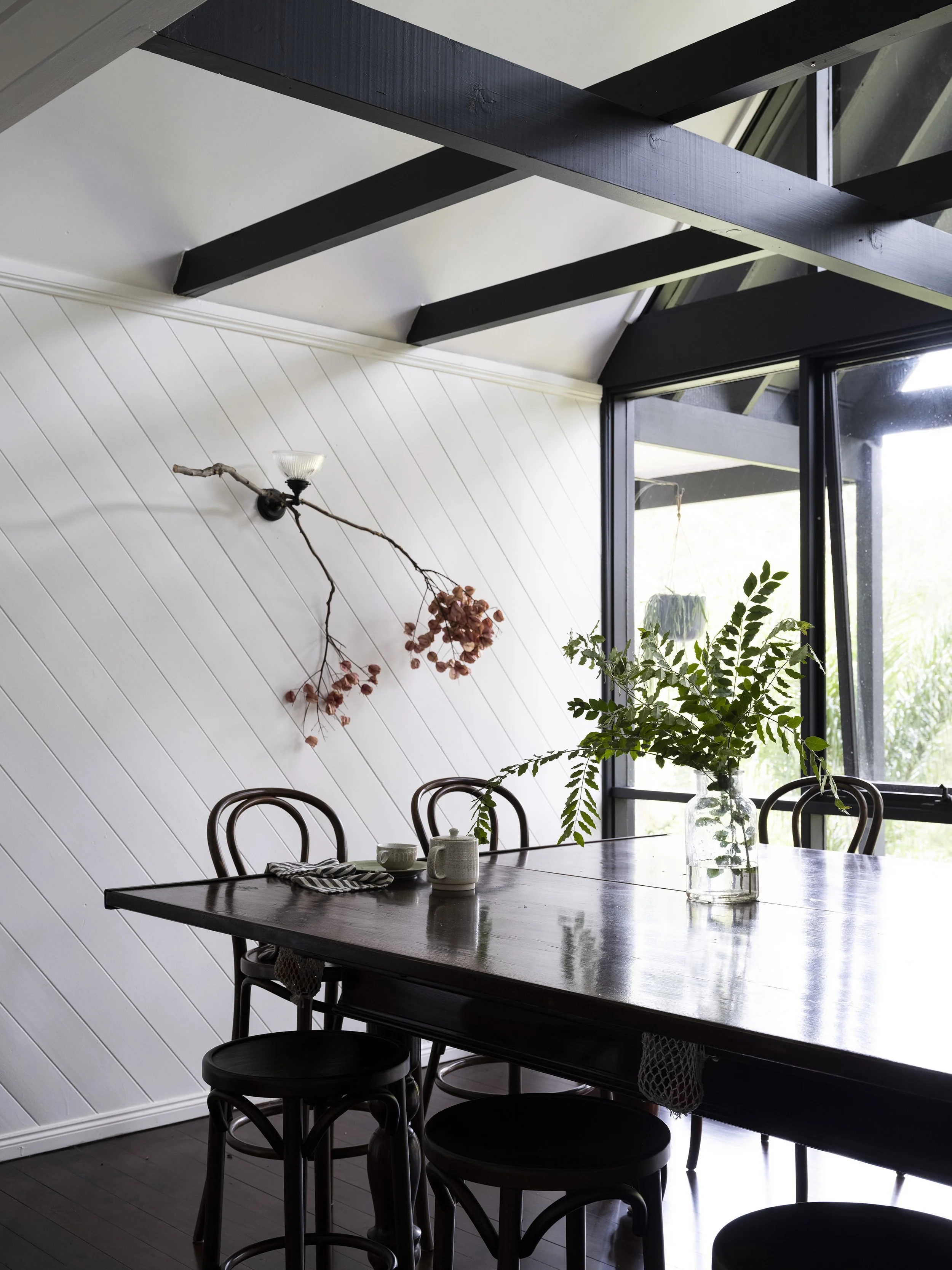 Seals Way dining room with sculptural lighting and tree canopy views