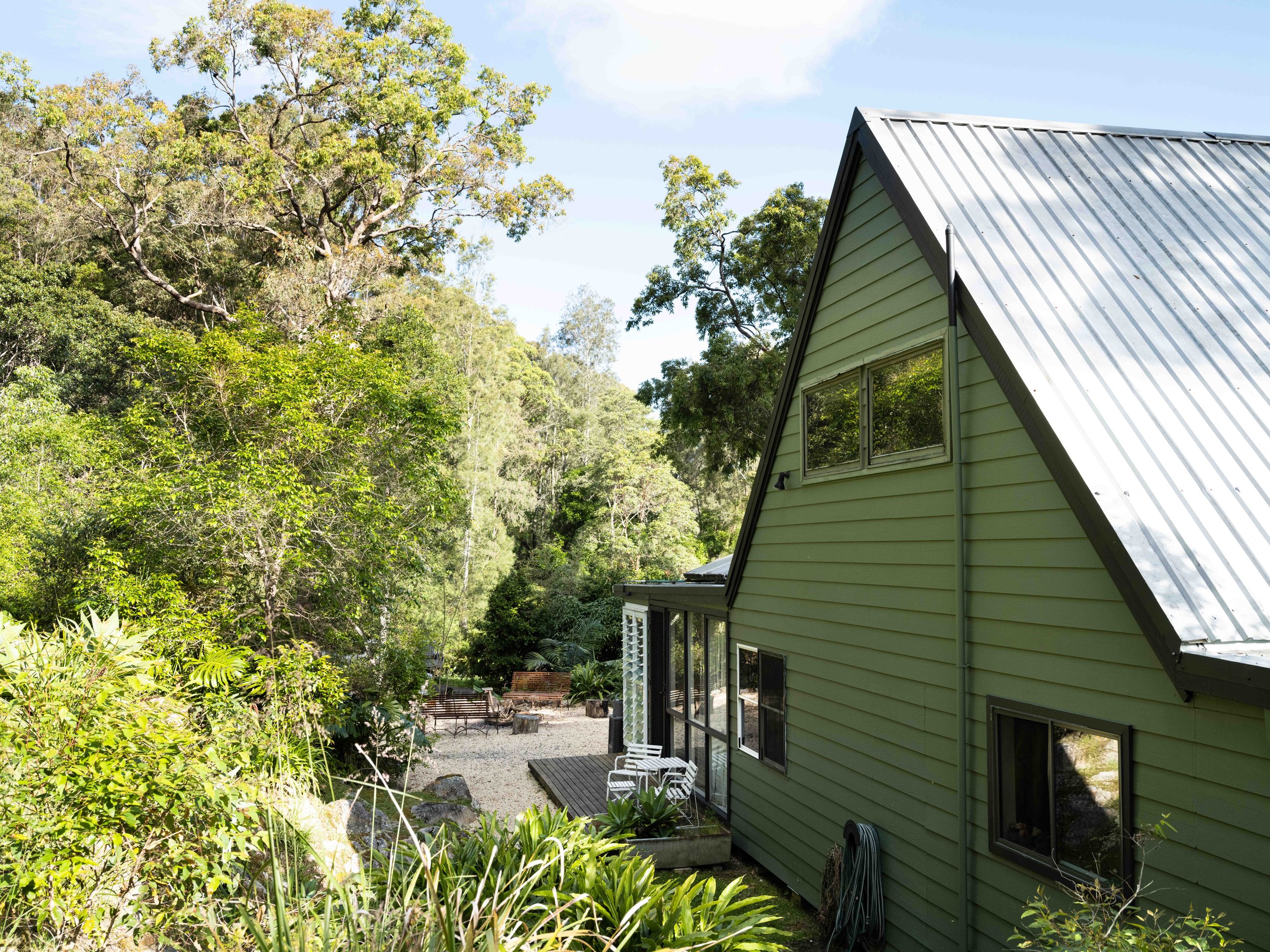 A-frame cabin exterior at Seals Way surrounded by native trees and bush garden