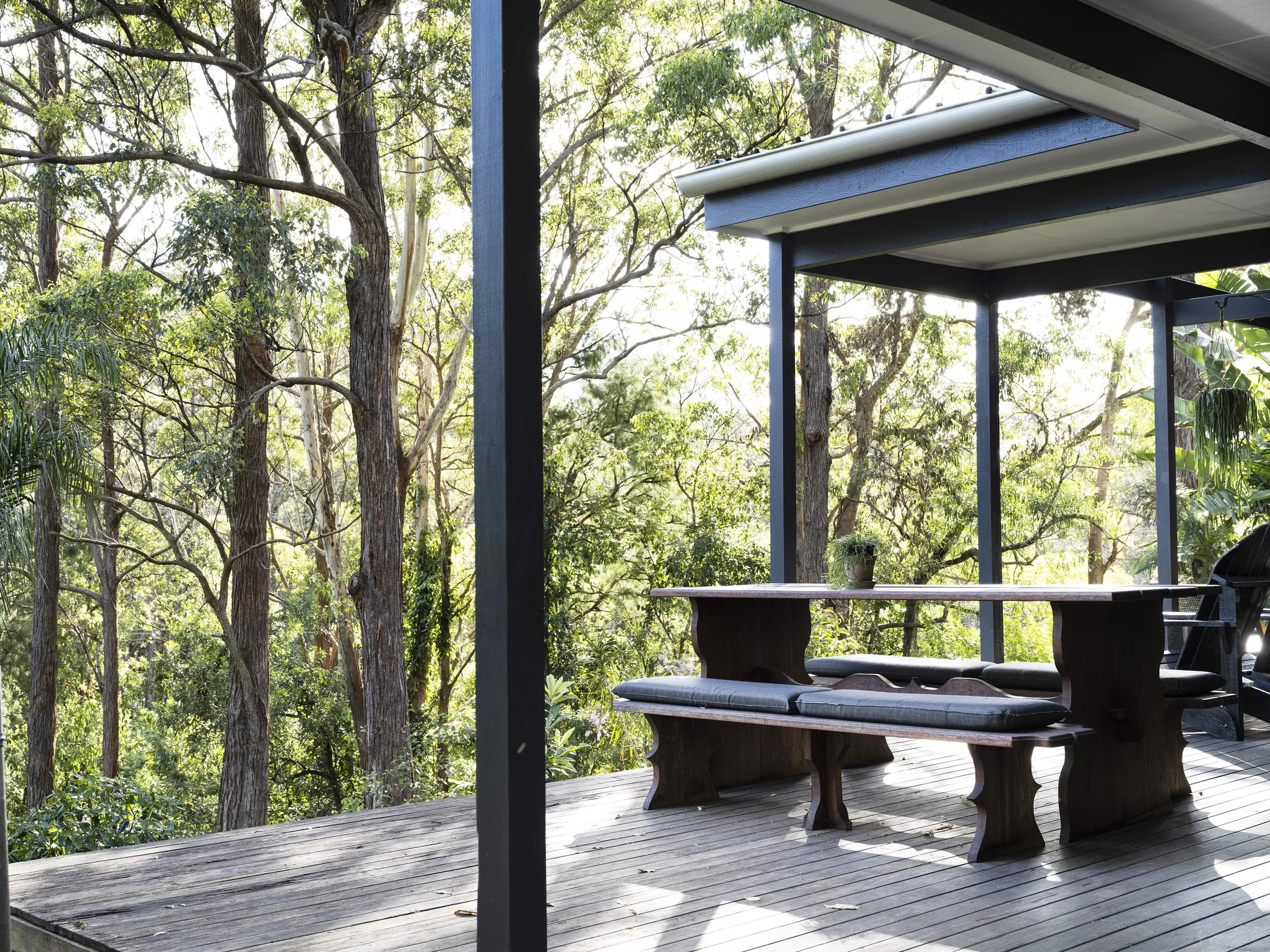 Outdoor dining deck at Seals Way with tranquil forest backdrop