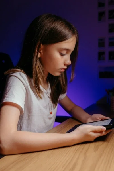 Girl sitting at desk looking at a smart phone