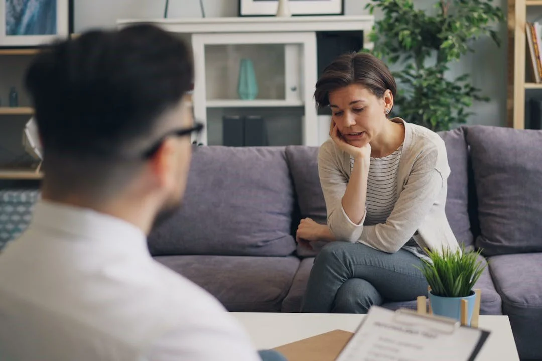 a-woman-sitting-on-a-couch-talking-to-a-man