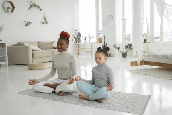 Mom and daughter meditating on the floor together