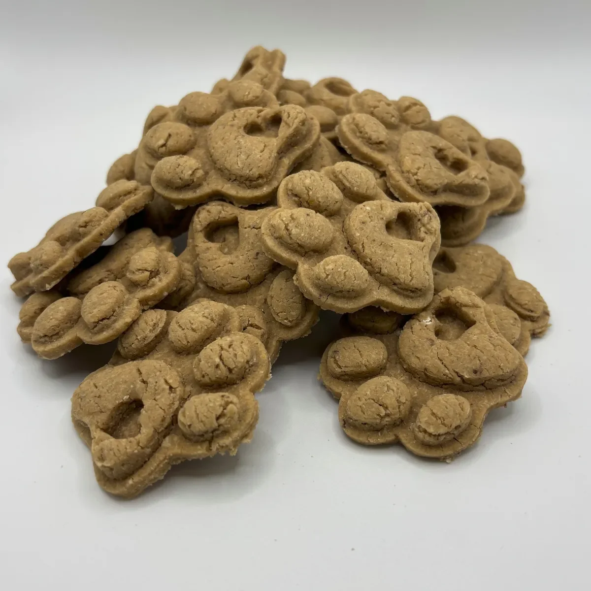 A pile of peanute butter paw shaped dog treats