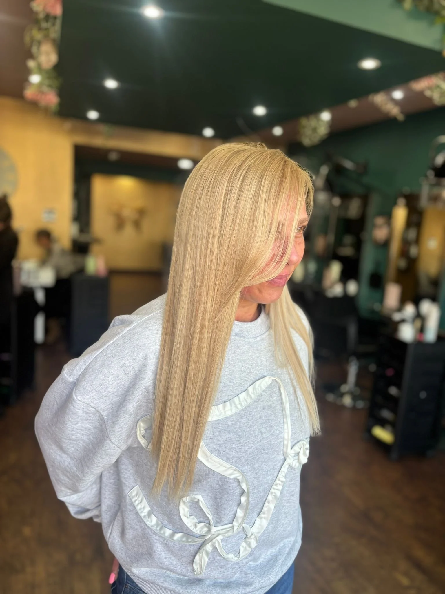 Woman with long, straight blonde hair in a hair salon.