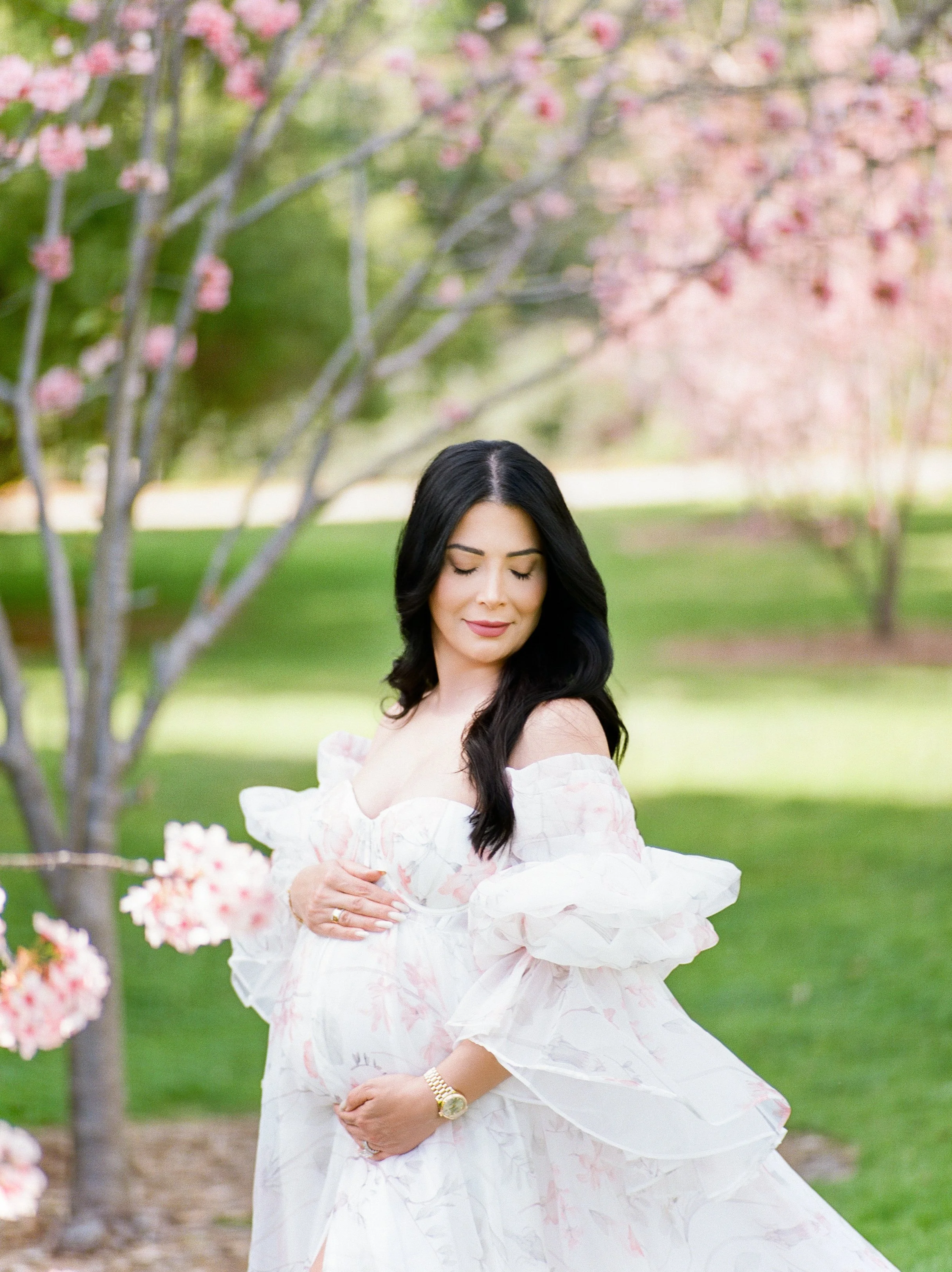 Cherry Blossom Photoshoot ideas featuring a maternity portrait partially visible beneath overlayed editing screens, showing a woman in a soft, flowing dress surrounded by cherry blossoms in a light, airy spring setting