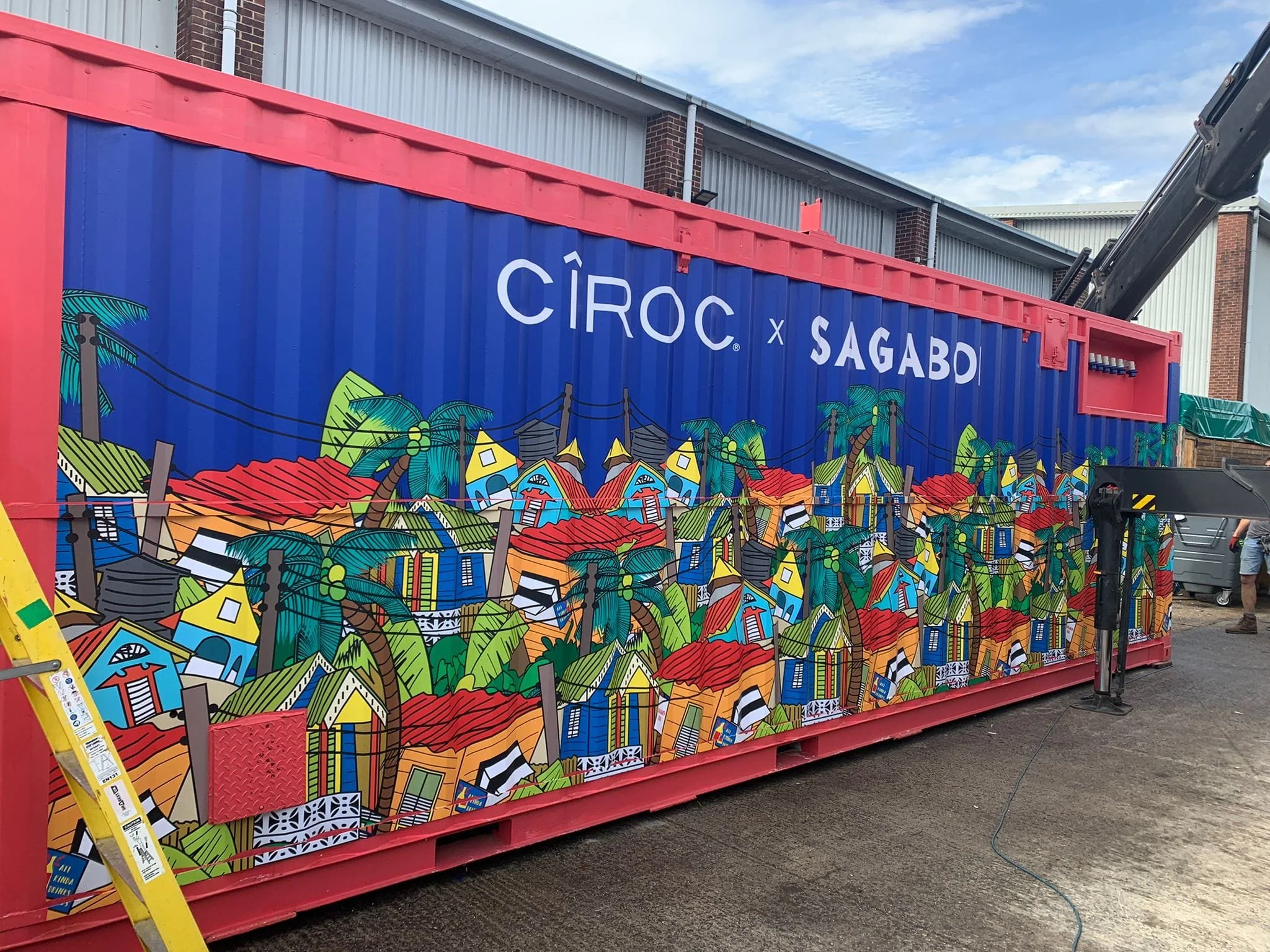 Colorful mural on a large shipping container with houses, trees, and electrical poles, displaying the text 'CÎROC x SAGABO'.