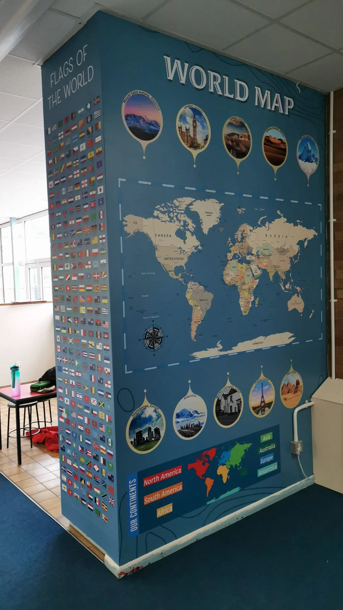 A large educational display featuring a world map, flags of countries, and images representing different continents and famous landmarks.