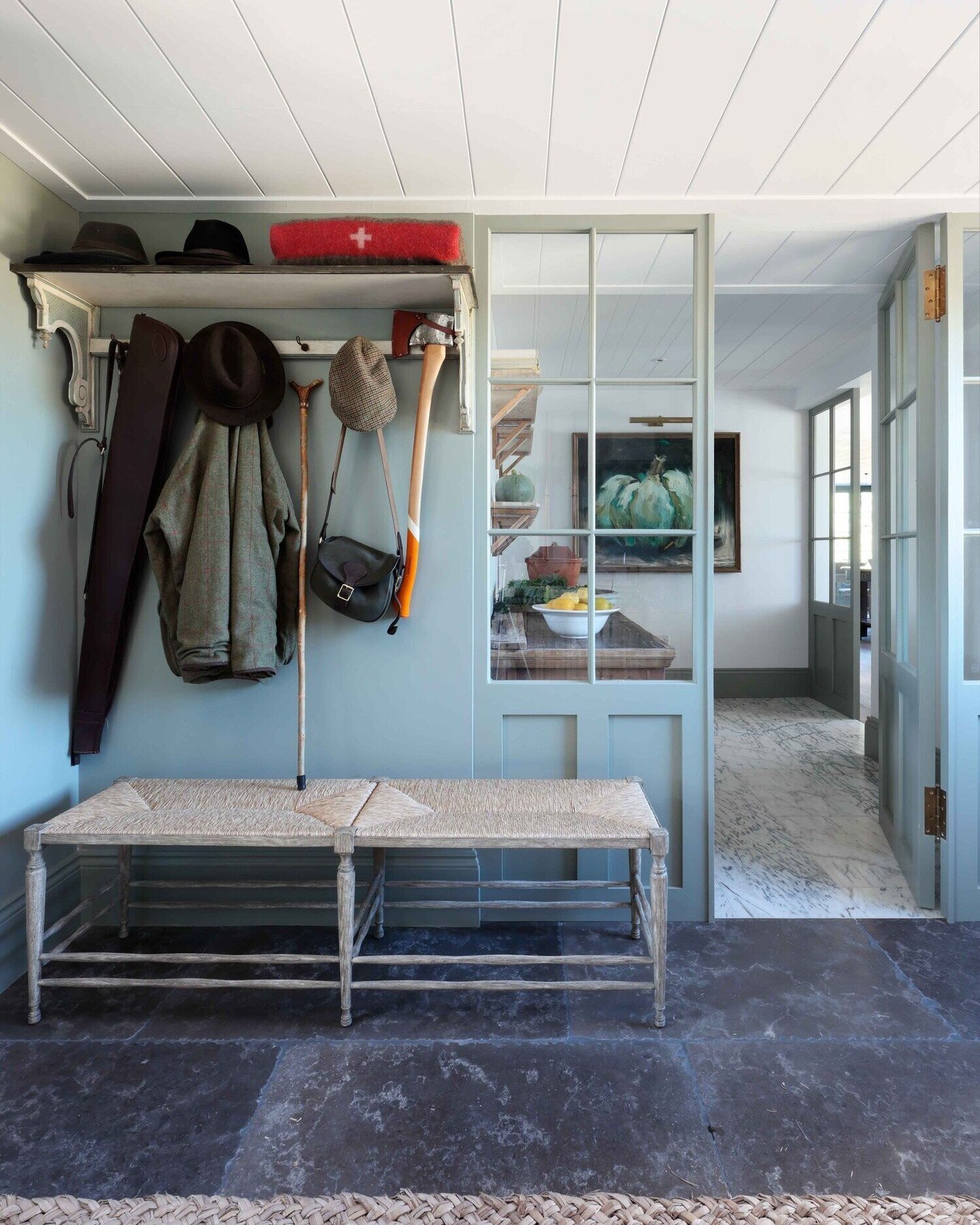 A hardworking countryside boot room featuring our signature shiplap boarded ceilings, textural materials, bold pops of colour, and antique and handcrafted furniture, giving this country home an established grace. For more from this project, search 'T