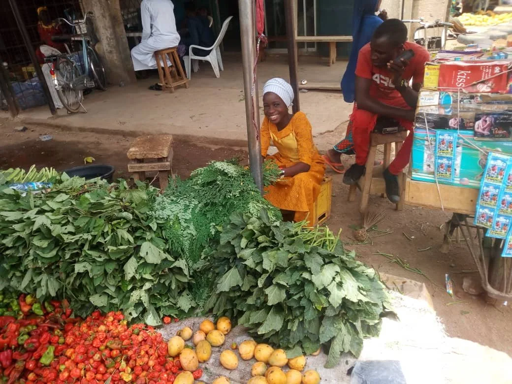 Light Group youth client helping her mother sell vegetables.jpeg
