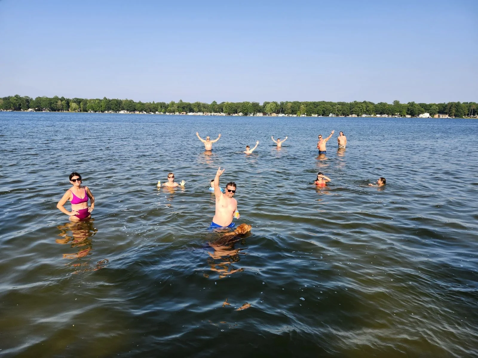 people wading shallow lake