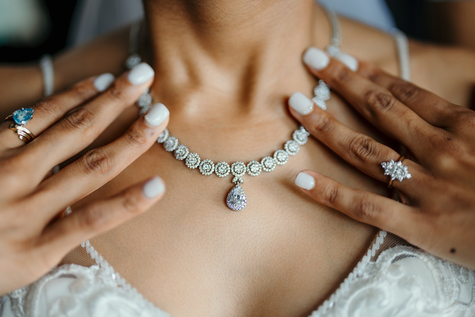    South Asian Indian bride gracefully holding her necklace, a detail photograph capturing the exquisite jewelry and the bride's elegant poise   