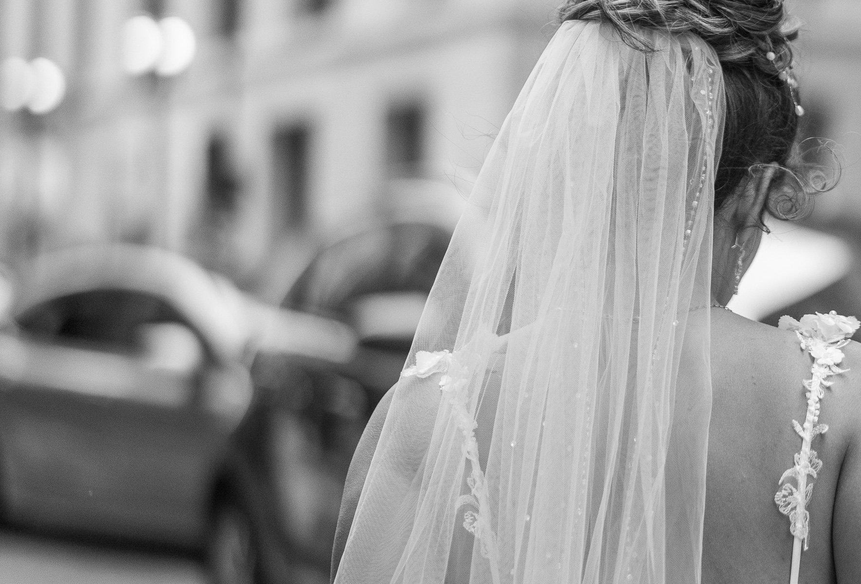    Elegant photograph of a bride's veil, highlighting the fine lace details and the soft, flowing fabric in a serene setting   