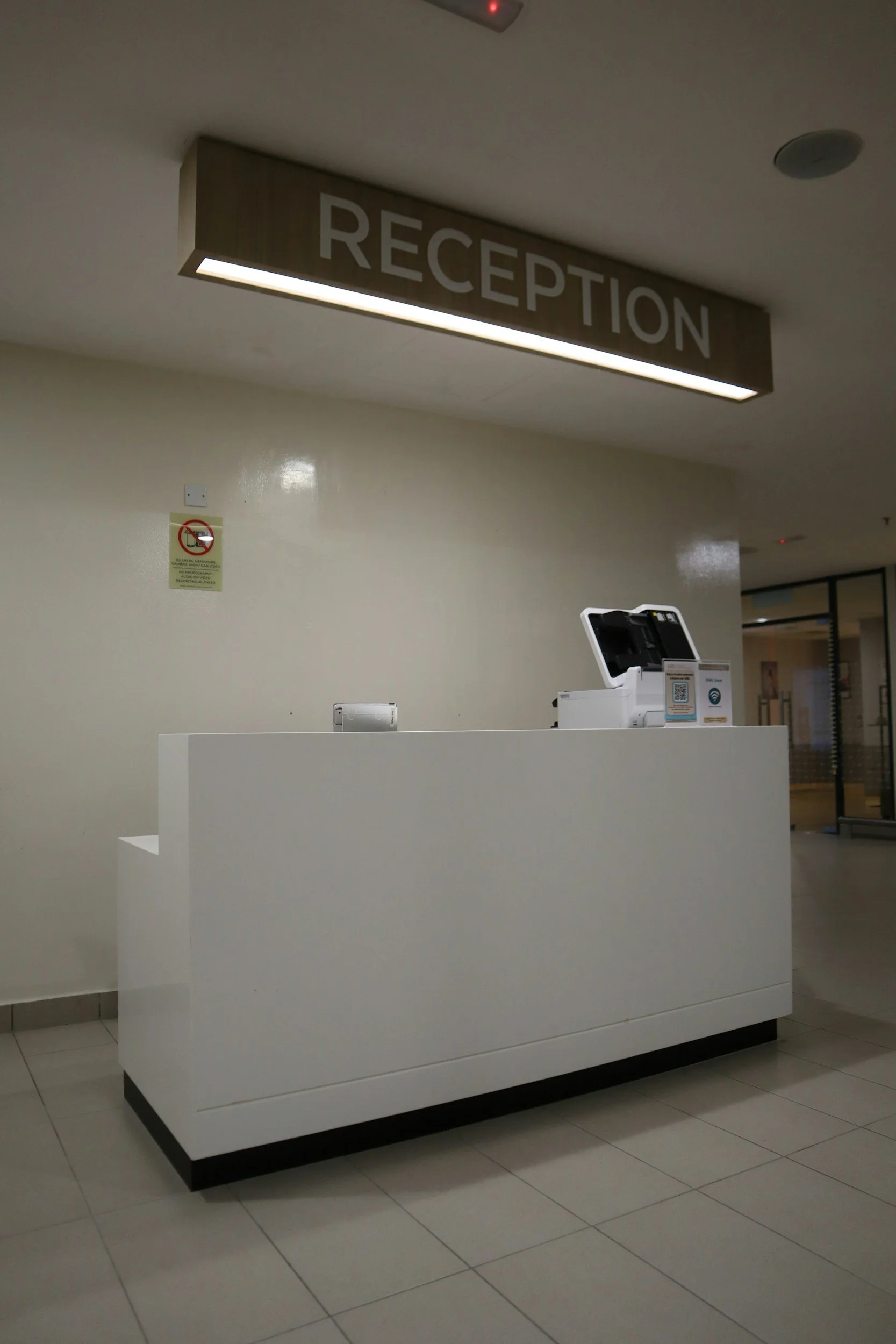 A clean medical facility showing a white desk reception area.