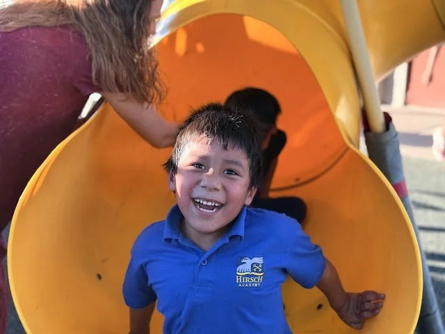 Four MentorKids USA students at Paiute Promise Neighborhood holding up hand-colored bookmarks celebrating Hispanic Heritage Month.