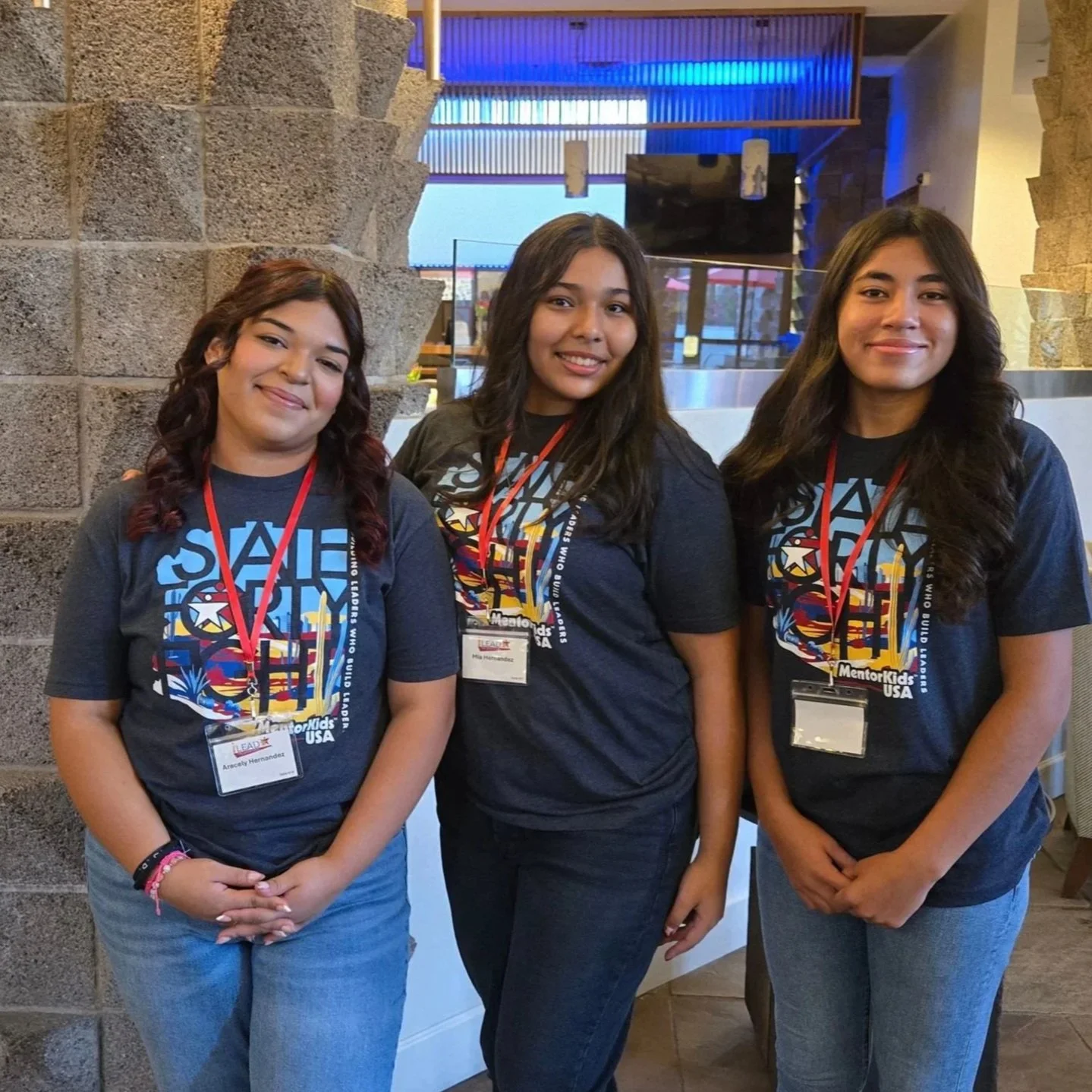 MentorKids USA volunteer with four elementary girls in handmade costumes and props during a creative activity at the Palomino Promise Neighborhood.