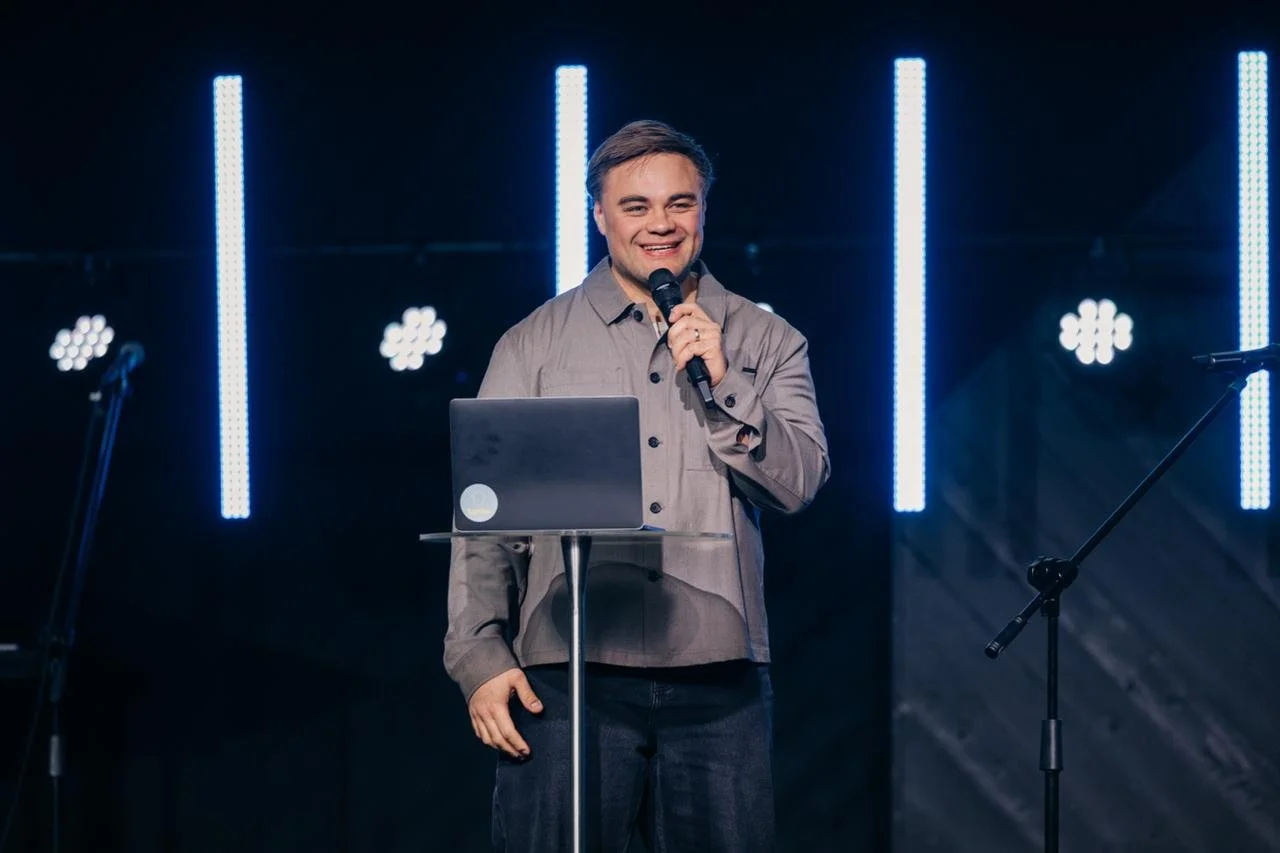 Pastor Zion Smiling While Holding Microphone