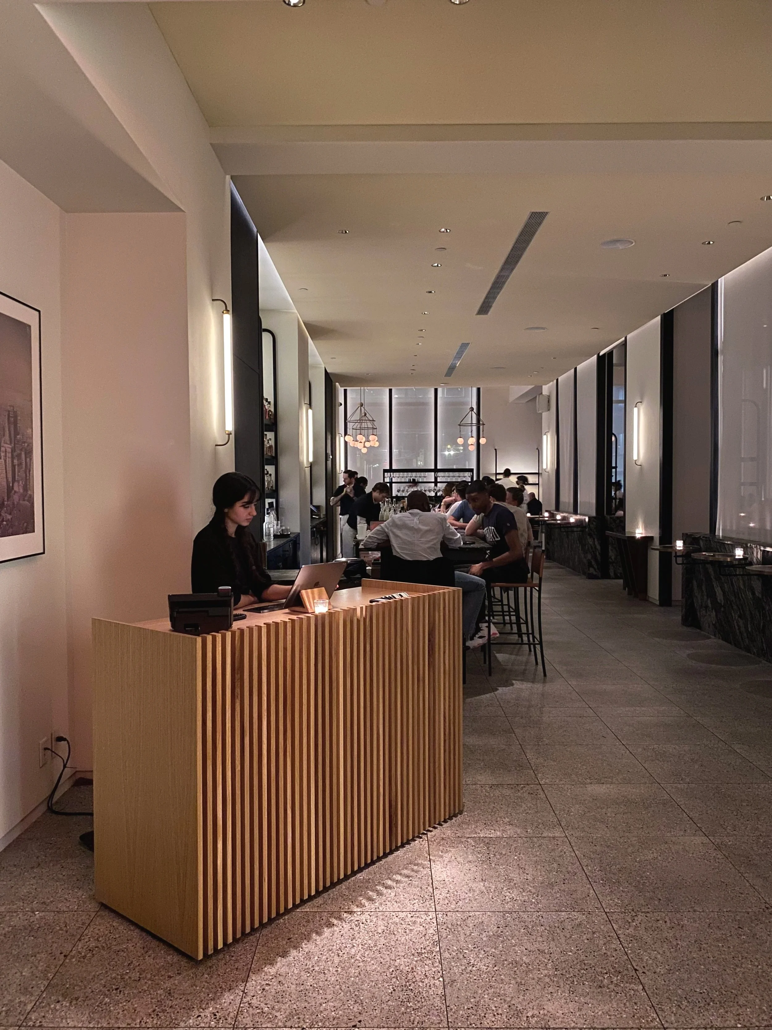 Large white oak host stand at the entrance of Crown Shy Restaurant in New York City