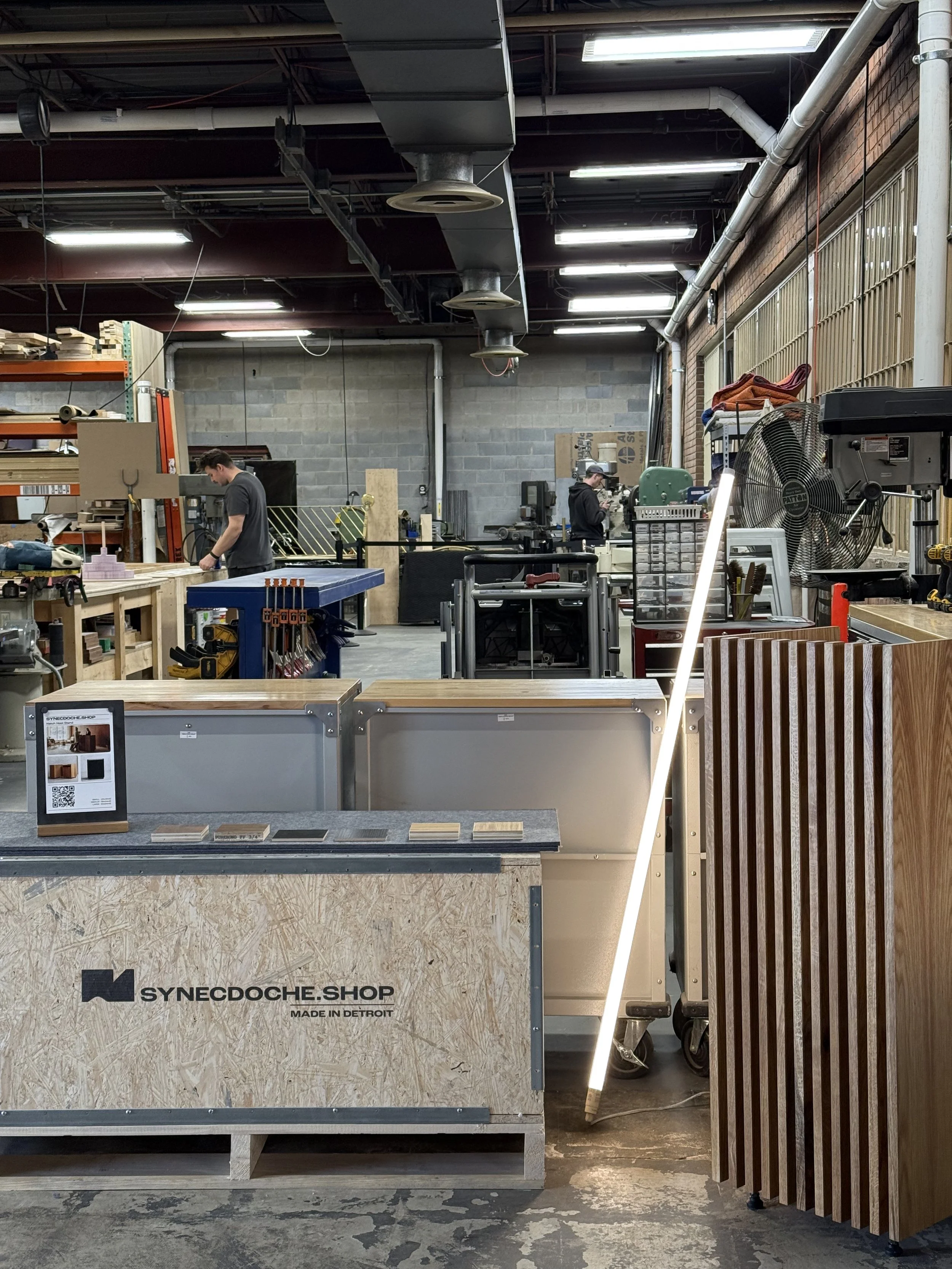 Synecdoche's shop space located in Detroit Michigan featuring a white oak host stand and shipping crate.
