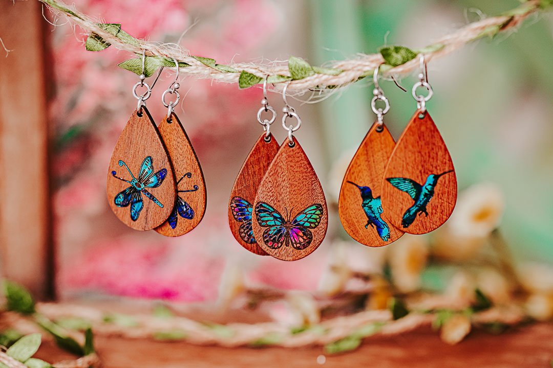 wooden earrings with butterfly, hummingbird and dragonfly hanging on a vine