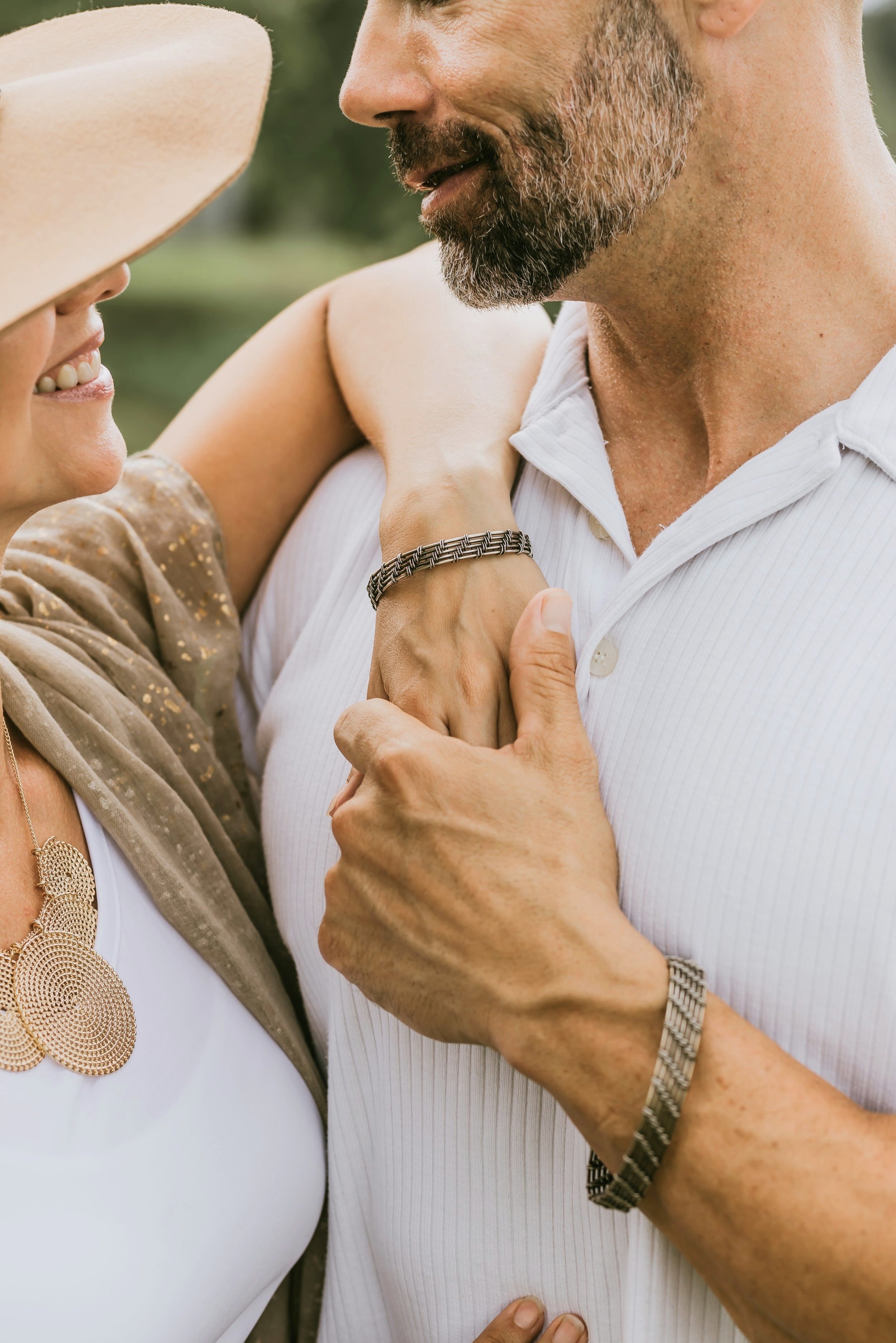 man and woman holding hands and modeling wire wrapped bracelet jewelry