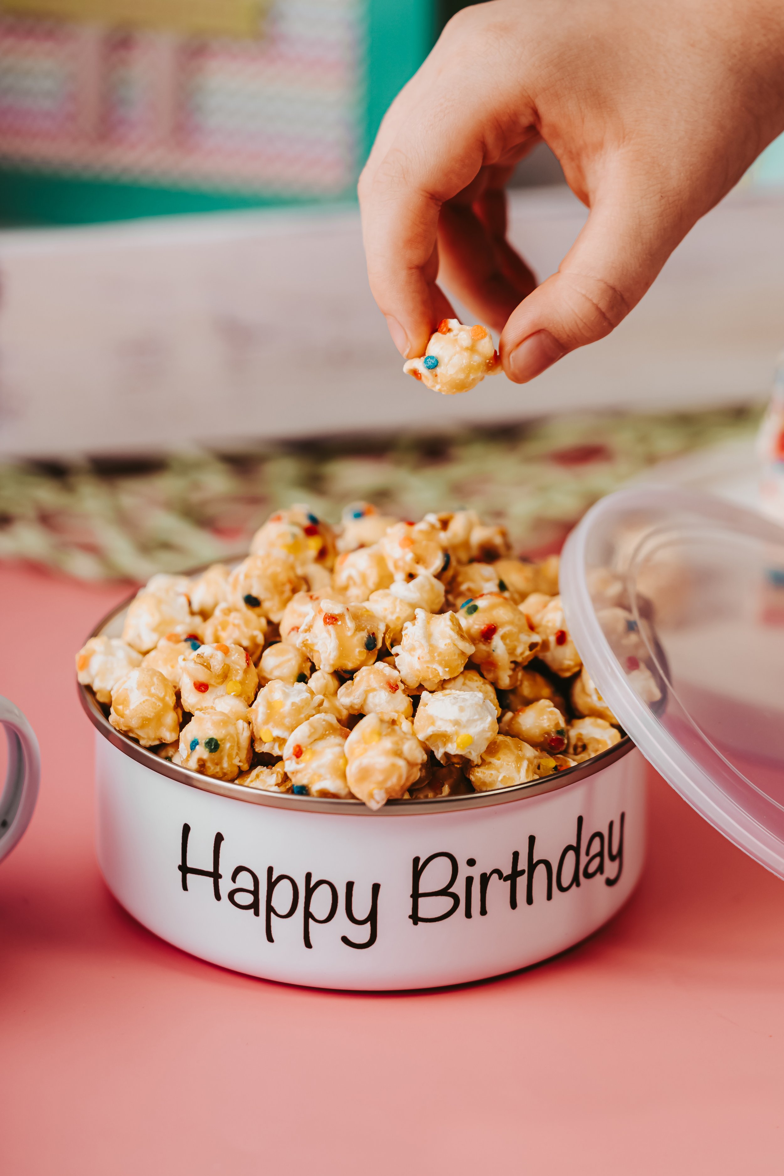hand model grabbing popcorn from a personalized gift bowl