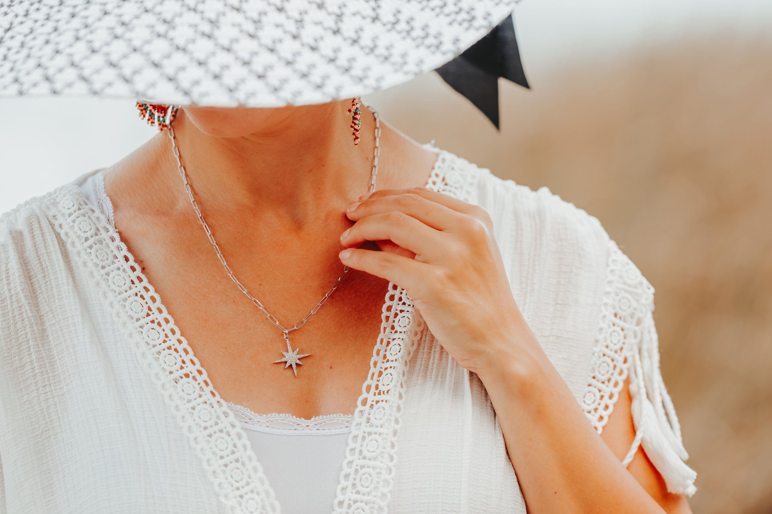 hand model wearing necklace adjusting necklace on neck